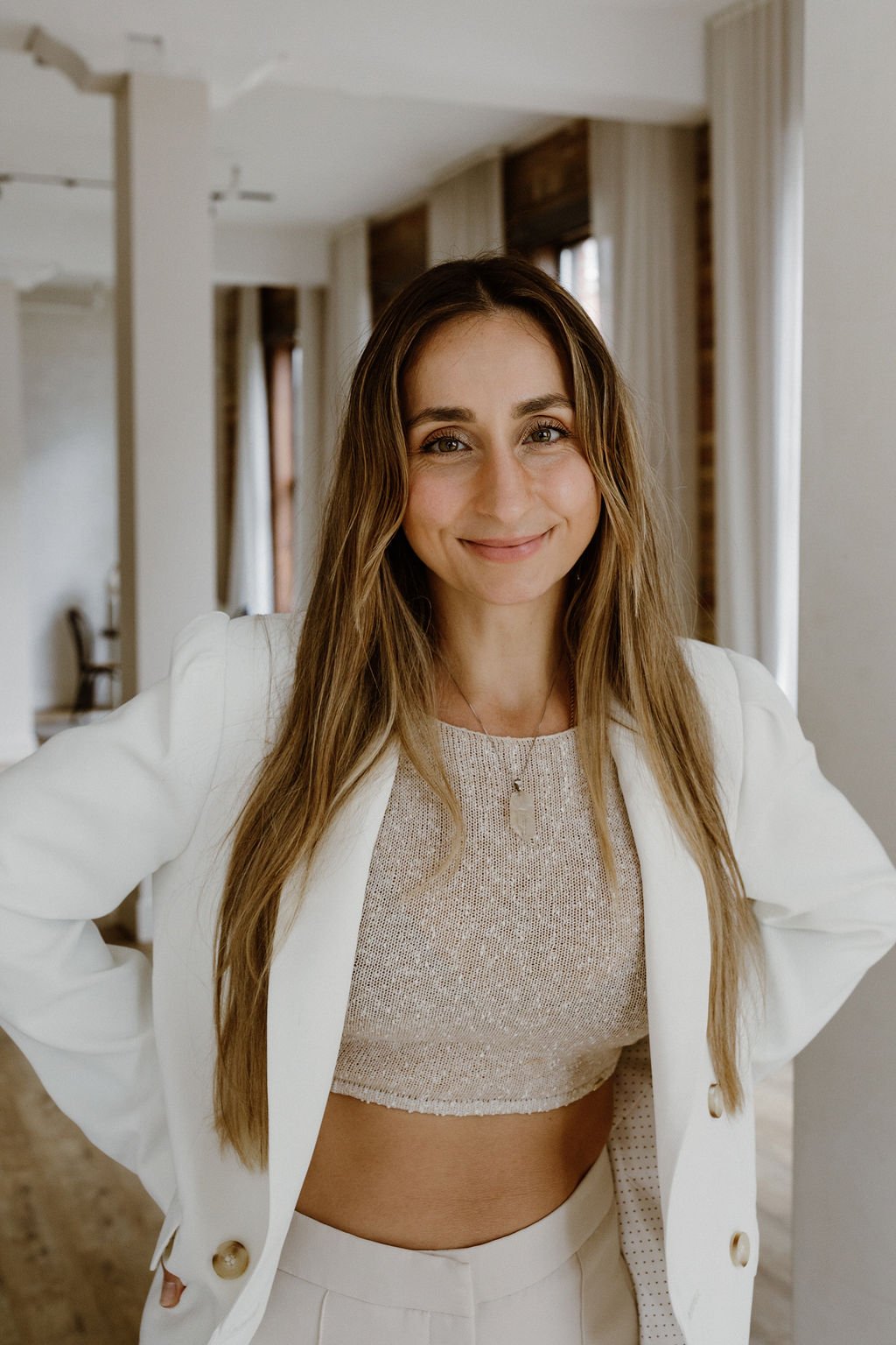 Natalie in a white blazer.