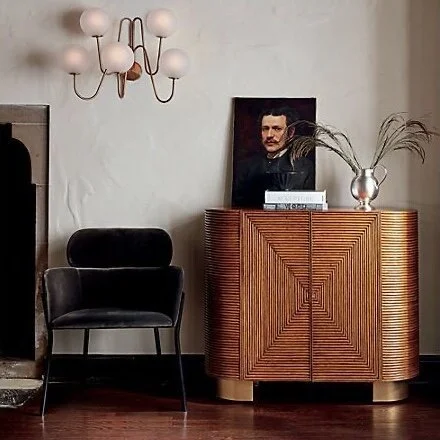  The Avalon Rattan Bar from  CB2  is sleek while nodding to some serious vintage vibes. The curves on the end are amazing, and I love the indentations so that wine can lay down inside the cabinet. Plus the feet make this one a show stopper. 