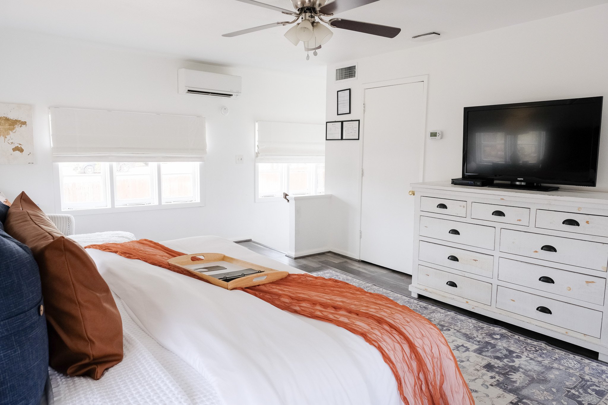 The Treehouse Suite also features modern bedroom furniture such as a white dresser with tv and a ceiling fan.