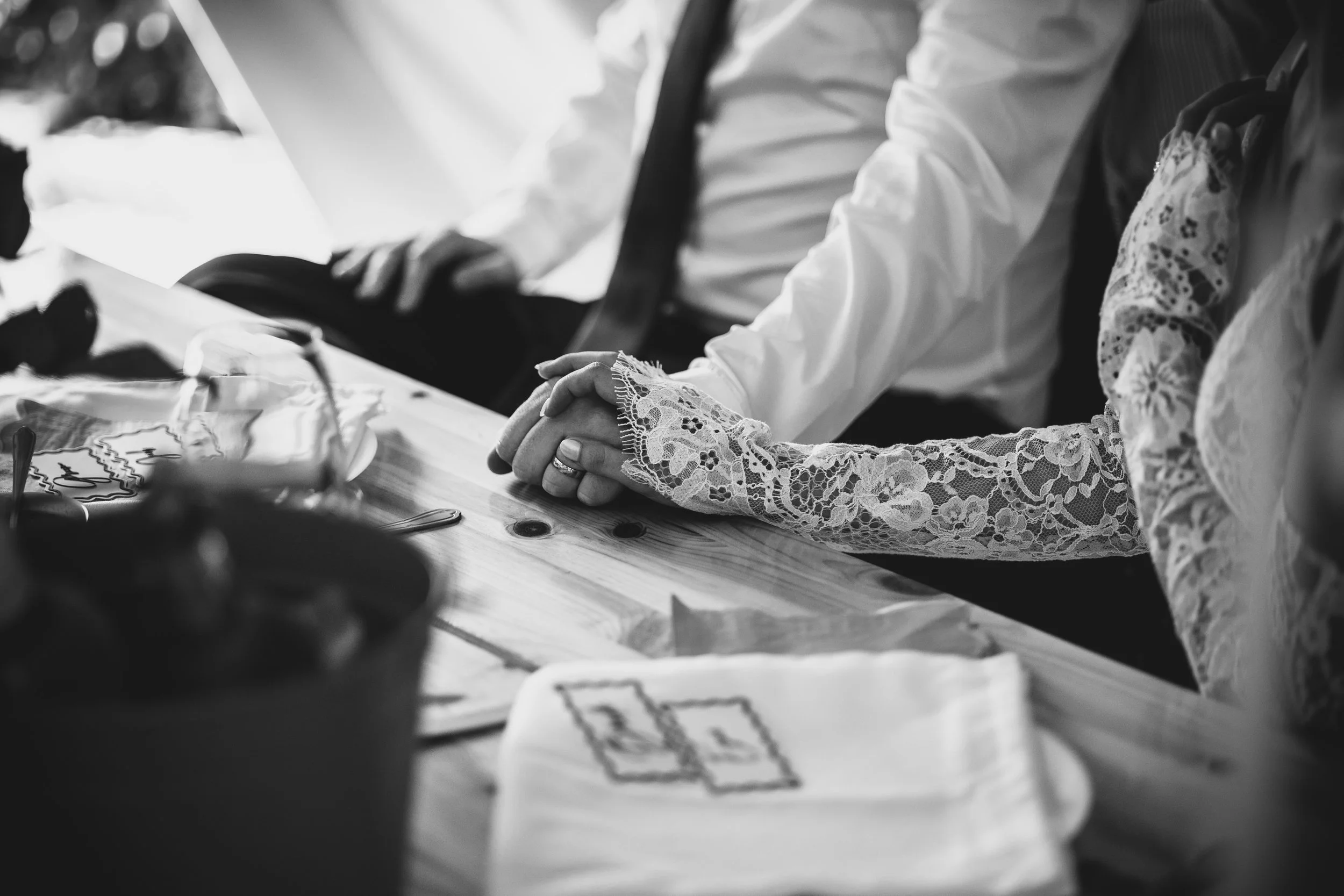 A black and white shot of Jack and Esme holding hands showing the details of Esme‘s dress at Inkersall Grange Farm wedding