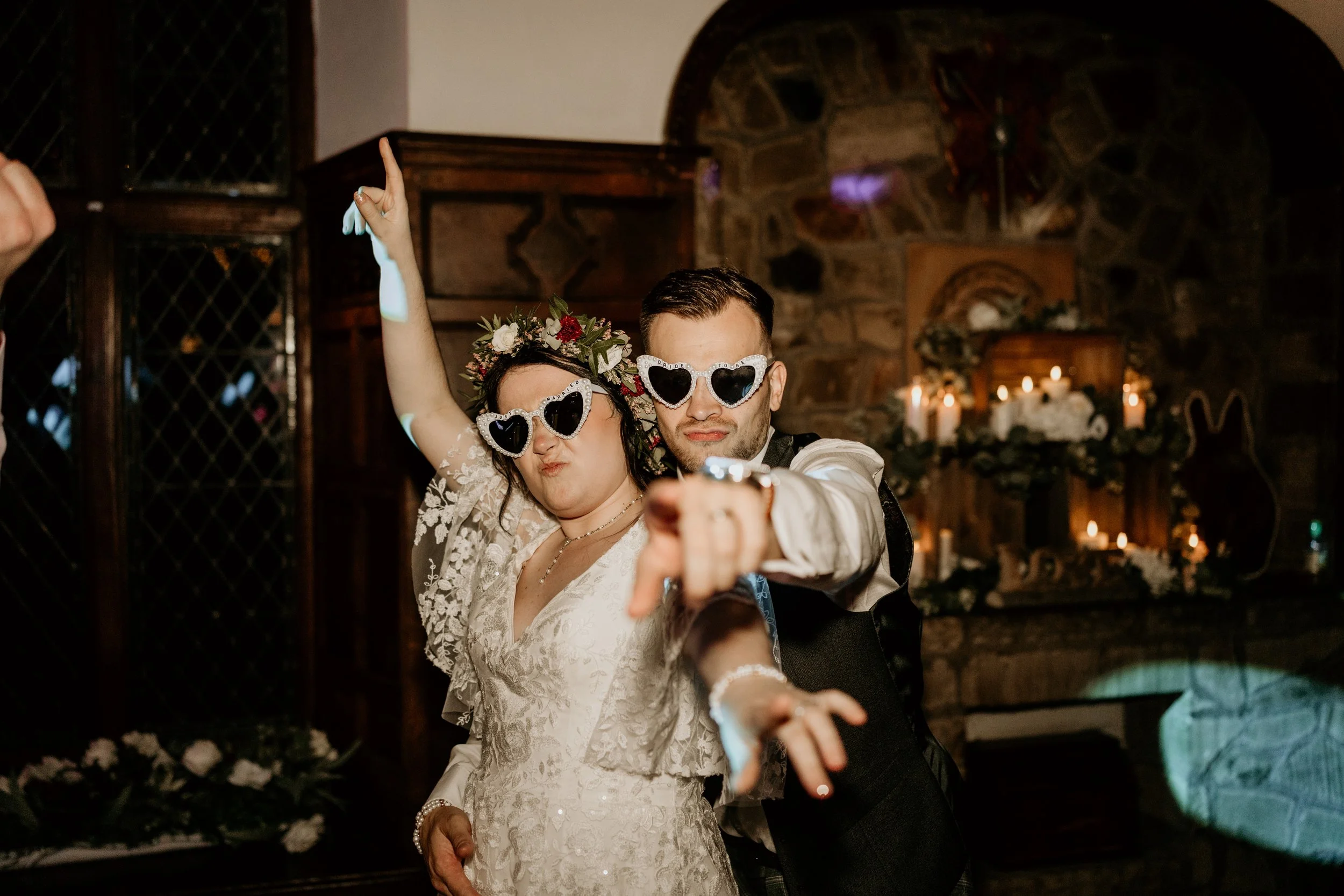 Relaxed wedding day shot Of Bride and groom posing with heart glasses on