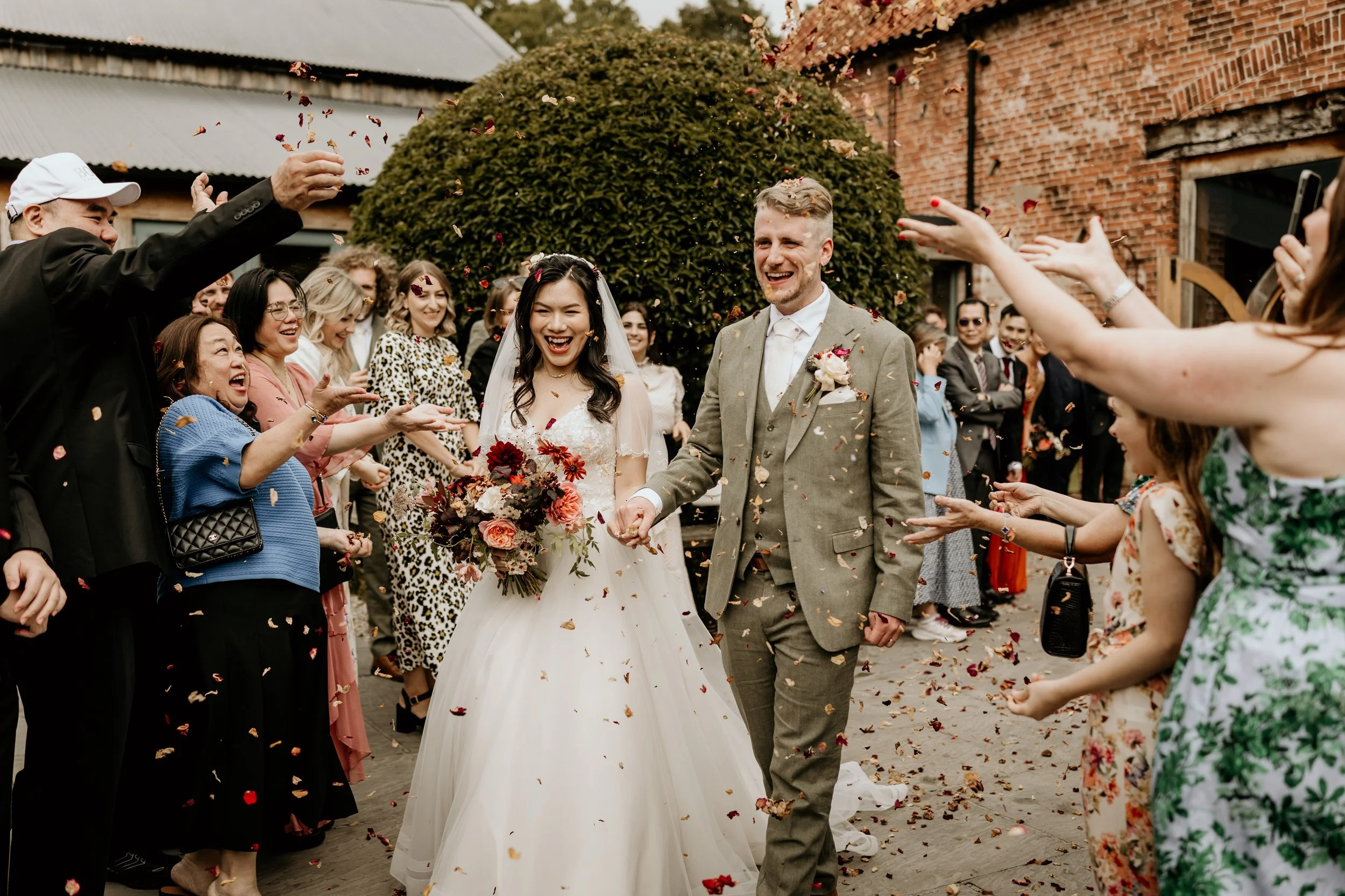 Relaxed wedding photography of the couple walking through during the confetti moment