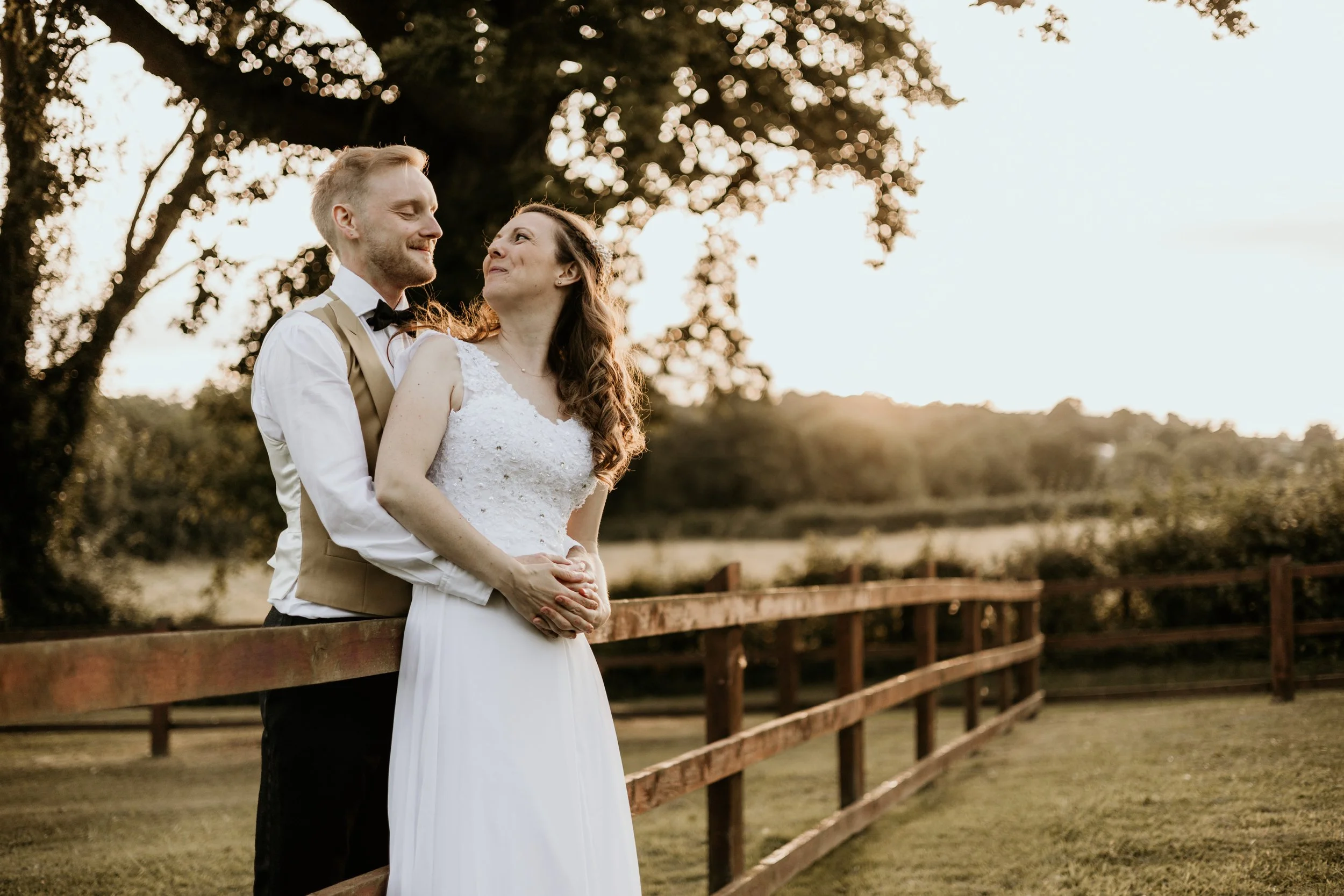 A relaxed wedding Day shot of the couple hand in hand looking at each other smiling