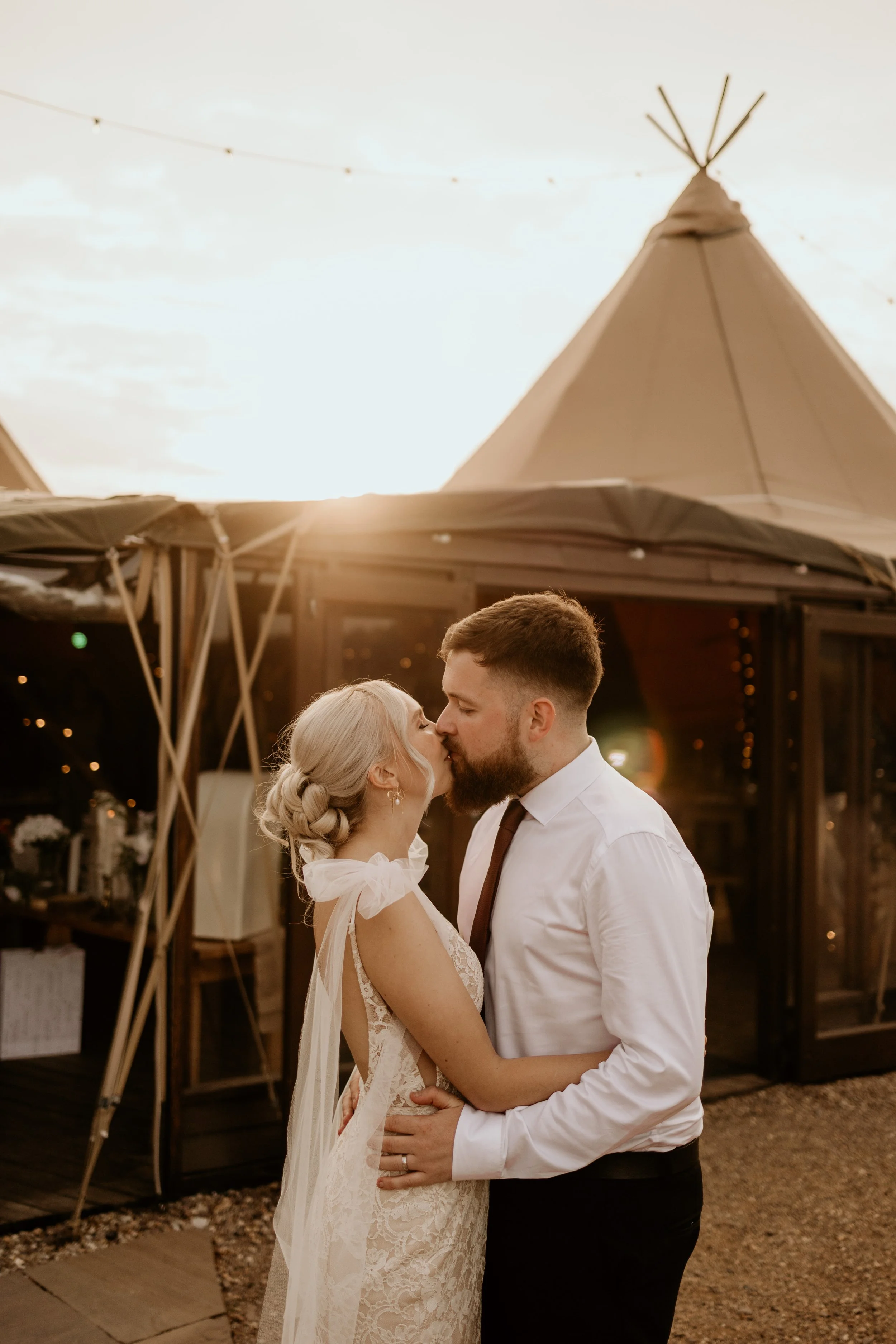 Jack and Esme kissing outside of the marquee at Inkersall Grange Farm wedding
