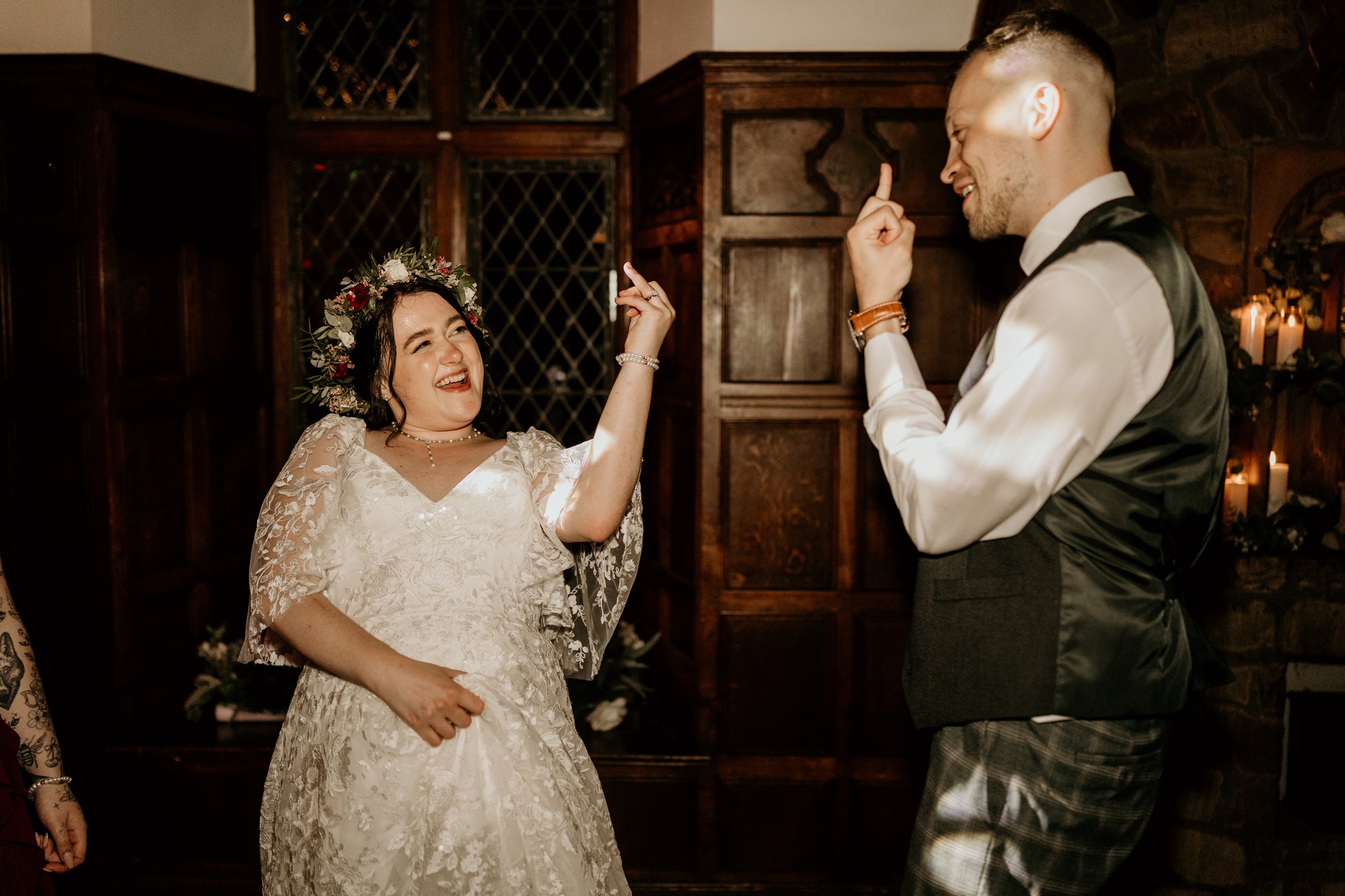 Couple smiling at each other showing off their wedding rings during relaxed wedding day