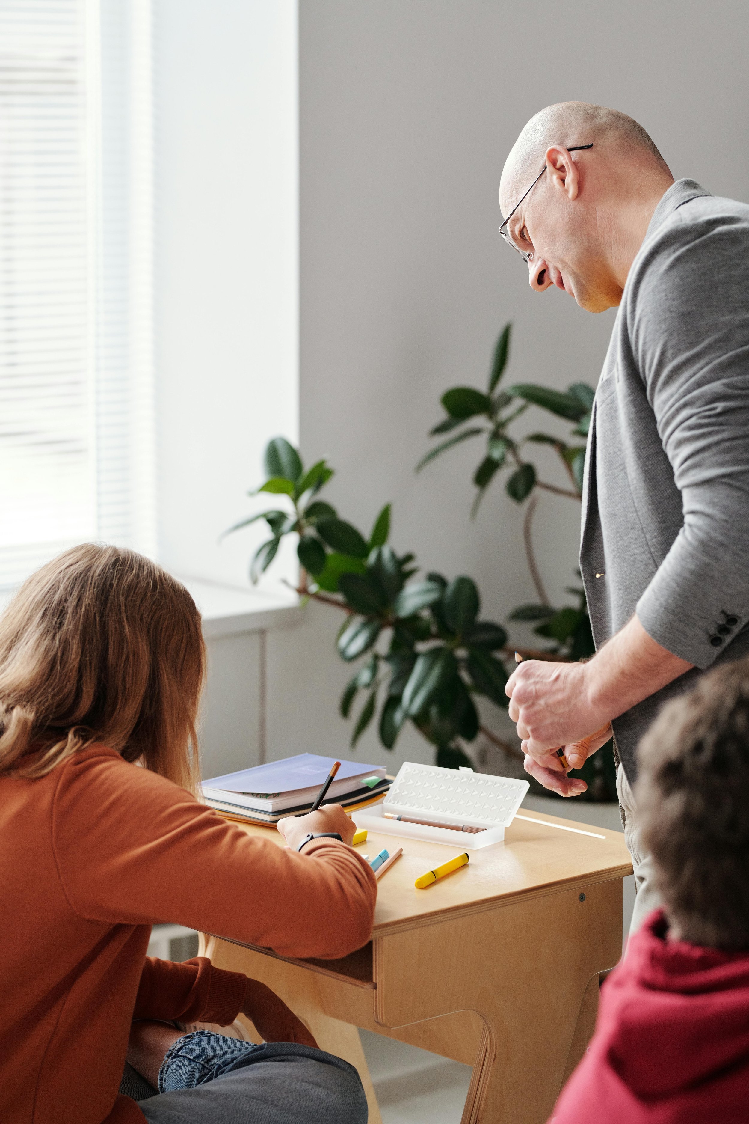 Teacher working with a student, representing early identification of learning, attention, or social challenges that may benefit from child psychological testing in Northern Virginia.