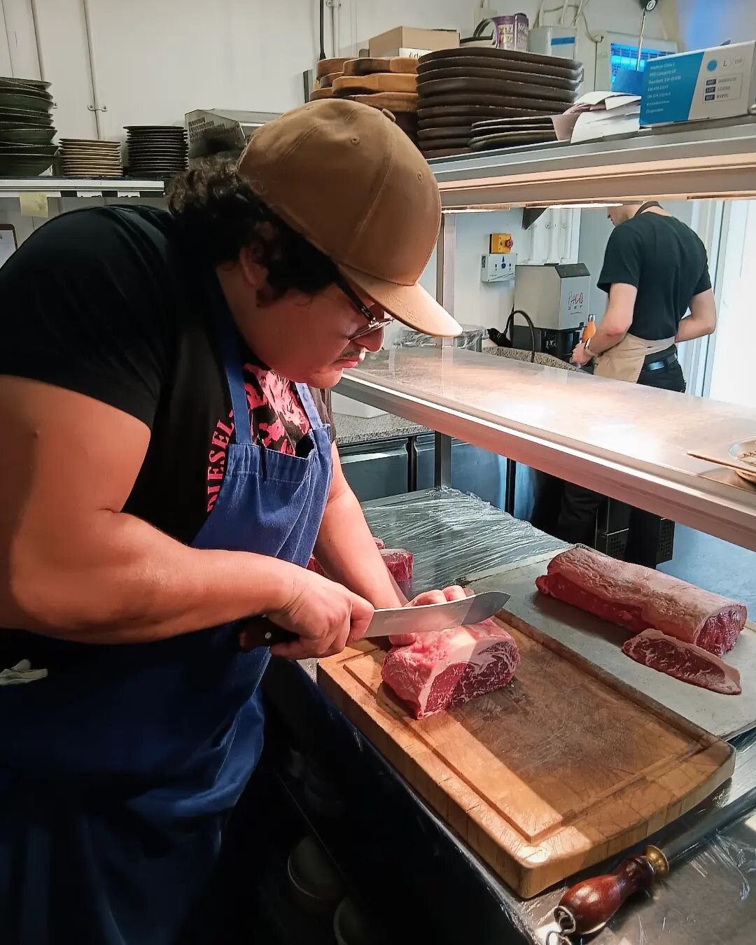 Head Chef Oscar preparing our beautiful sirloins, which we dry age for 2 weeks and cook over fire thanks to @dryager and @meat_cellar_and_co

Dry aging beef creates a much stronger flavour for the sirloin and allows the fat to cook much nicer, giving