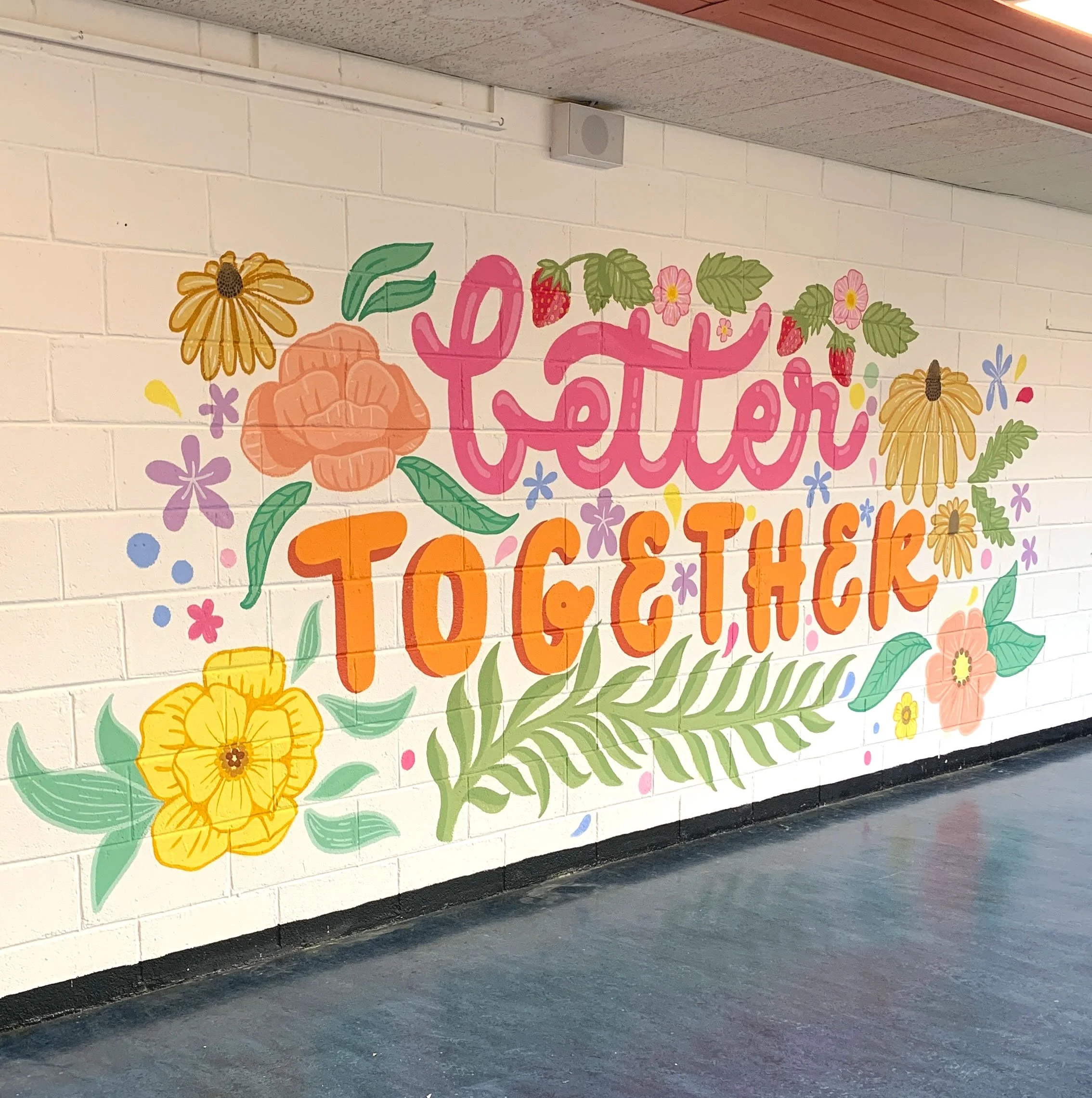 Brightly coloured school mural at Ramsgrange Community School canteen, featuring hand-painted florals, strawberries, and bubbly hand-lettered text reading ‘Better Together.’