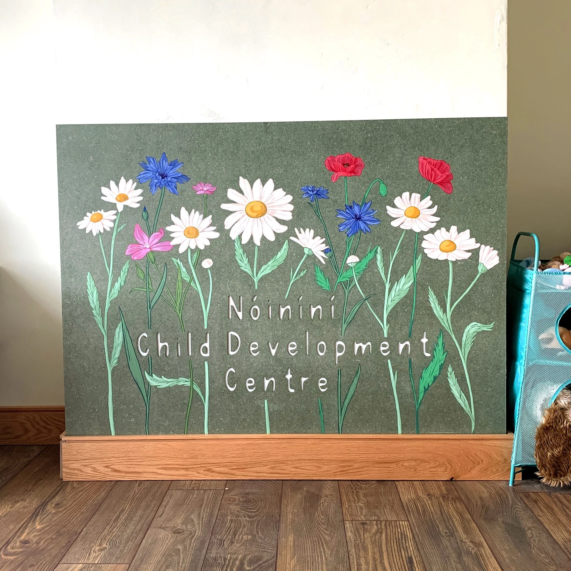 Hand-painted mural at Nóiníní Child Development Centre in Ireland featuring Irish wildflowers, delicate linework, and nature-inspired design