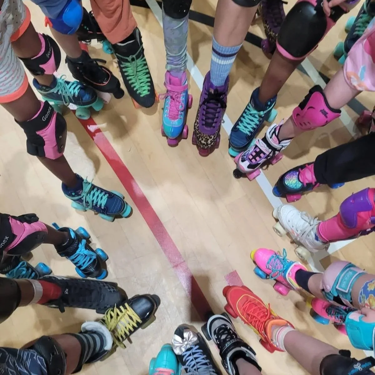 A variety of roller skates in a circle. These have different colours and styles.