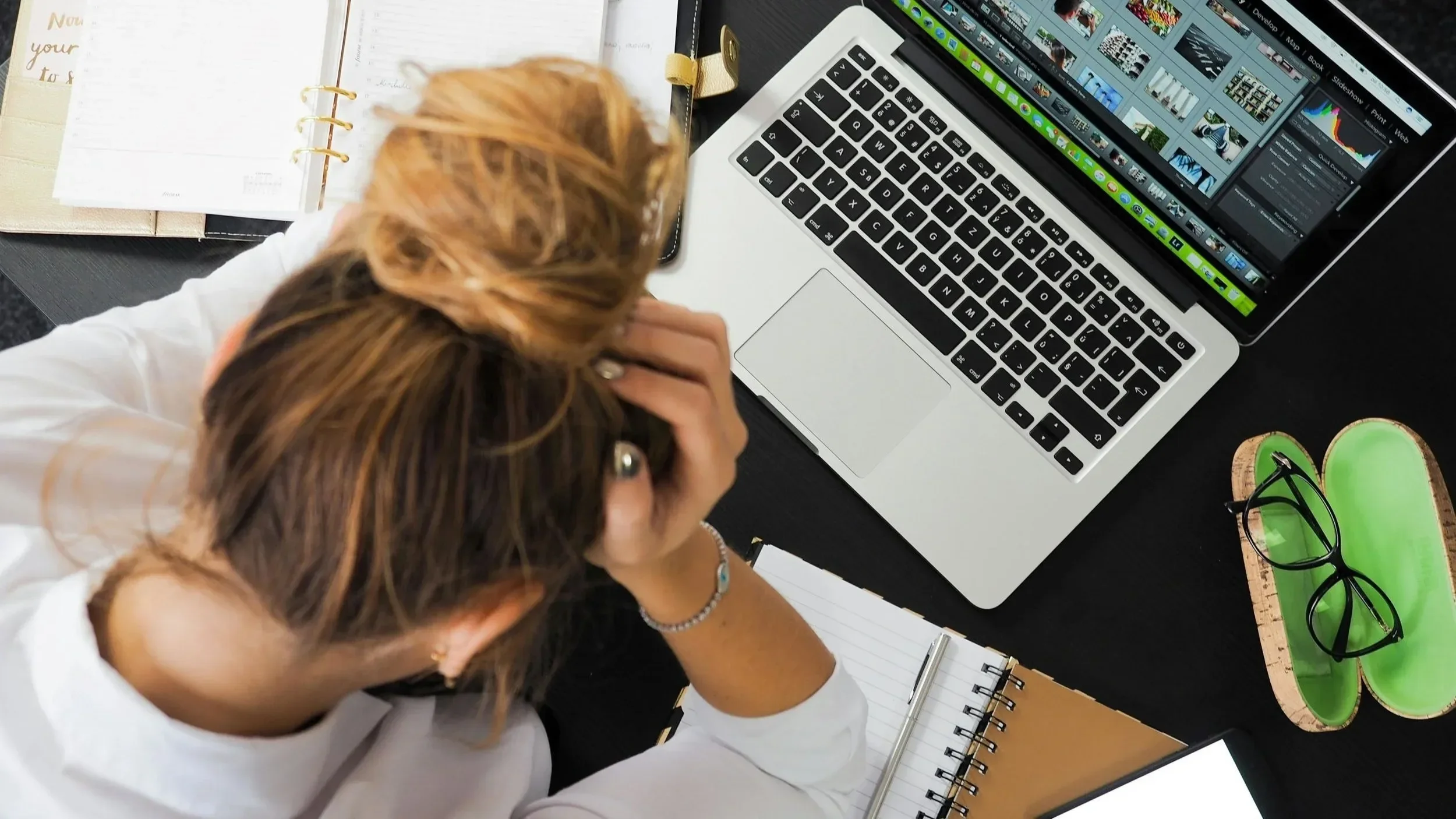 Erschöpfte Frau sitzt am Laptop und stützt den Kopf – Überlastung durch fehlende Abgrenzung im Job