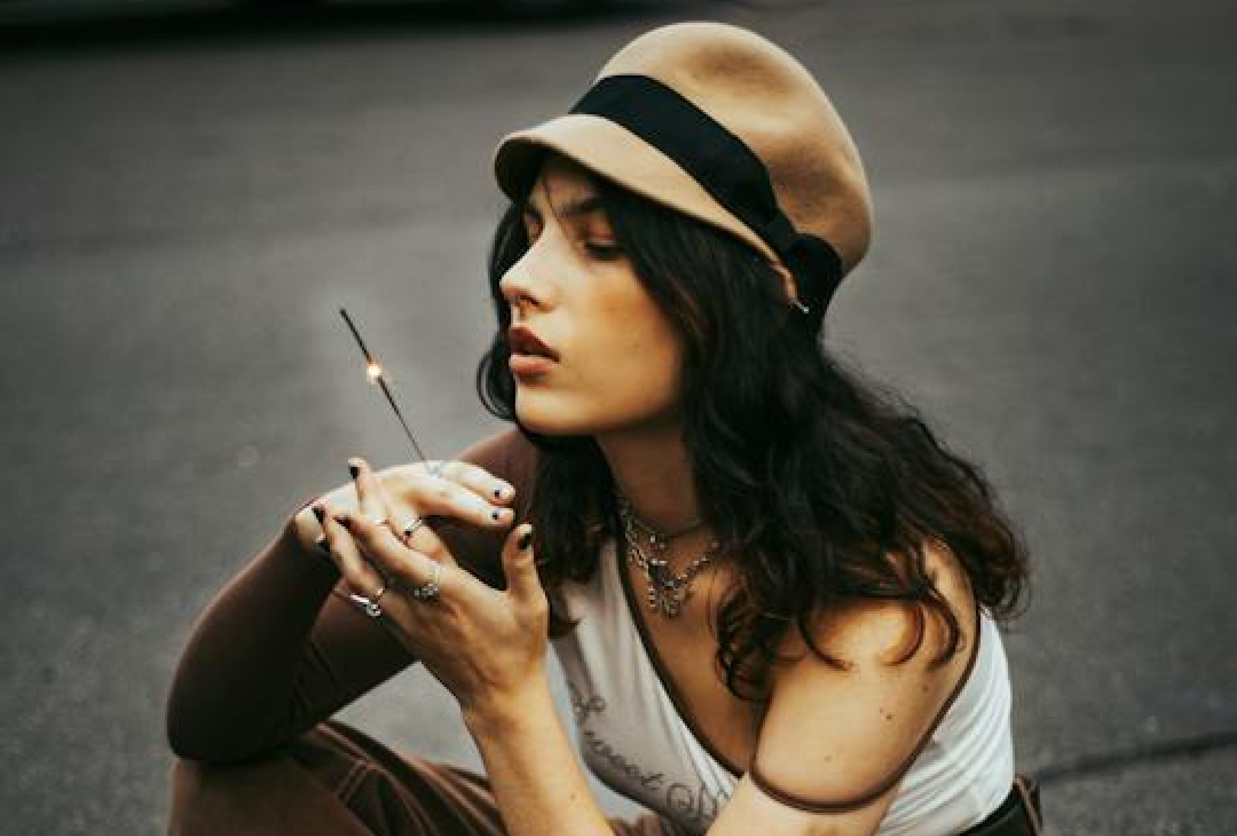 Nie wieder Burnout? Person sitzt auf dem Boden und betrachtet eine fast erloschene Wunderkerze in der Hand.