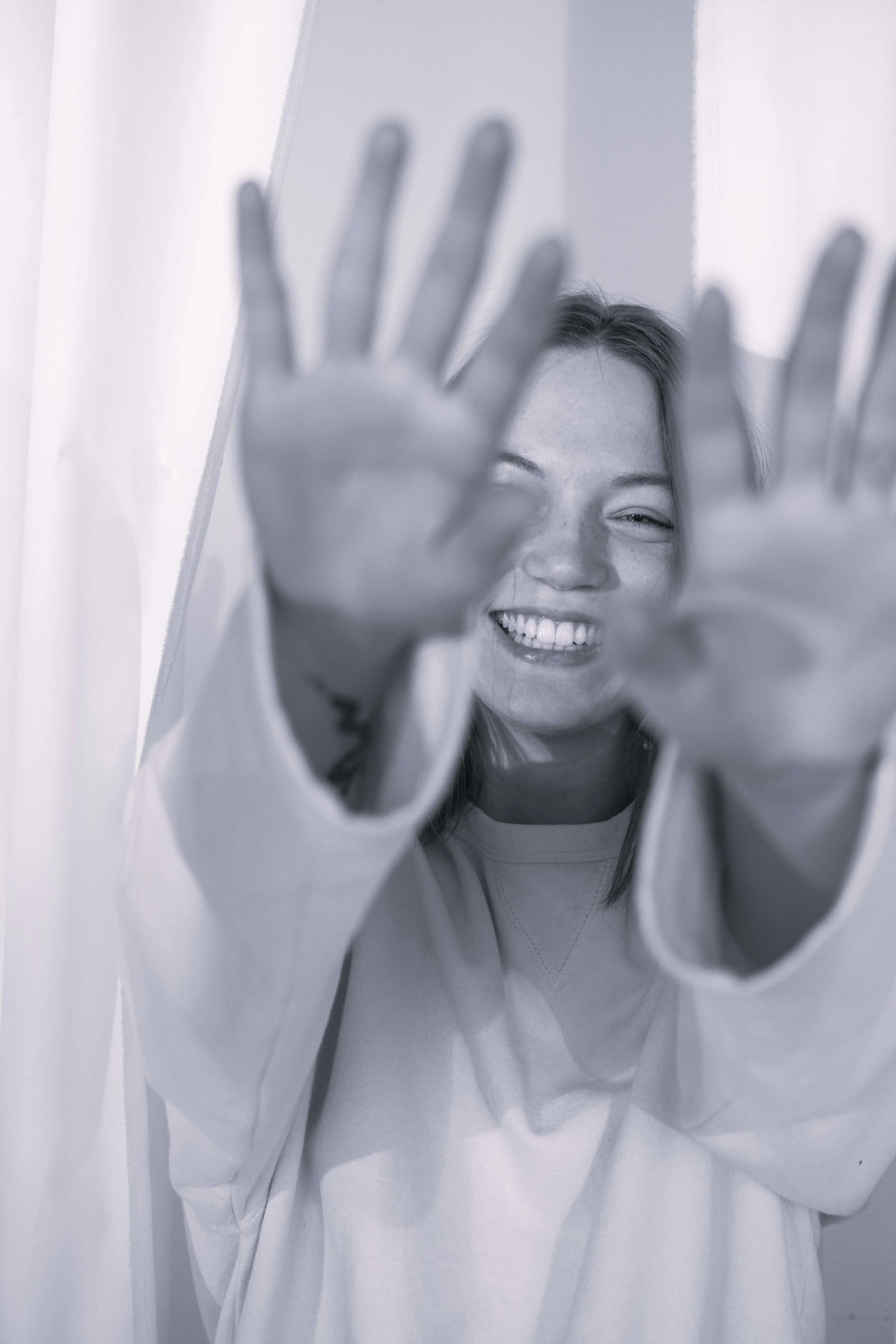 Frau hält lachend die Hände nach vorne als Symbol für selbstbewusst Nein sagen und Grenzen setzen