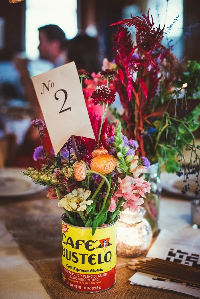 Vintage coffee tin used as rustic wedding centerpiece vase