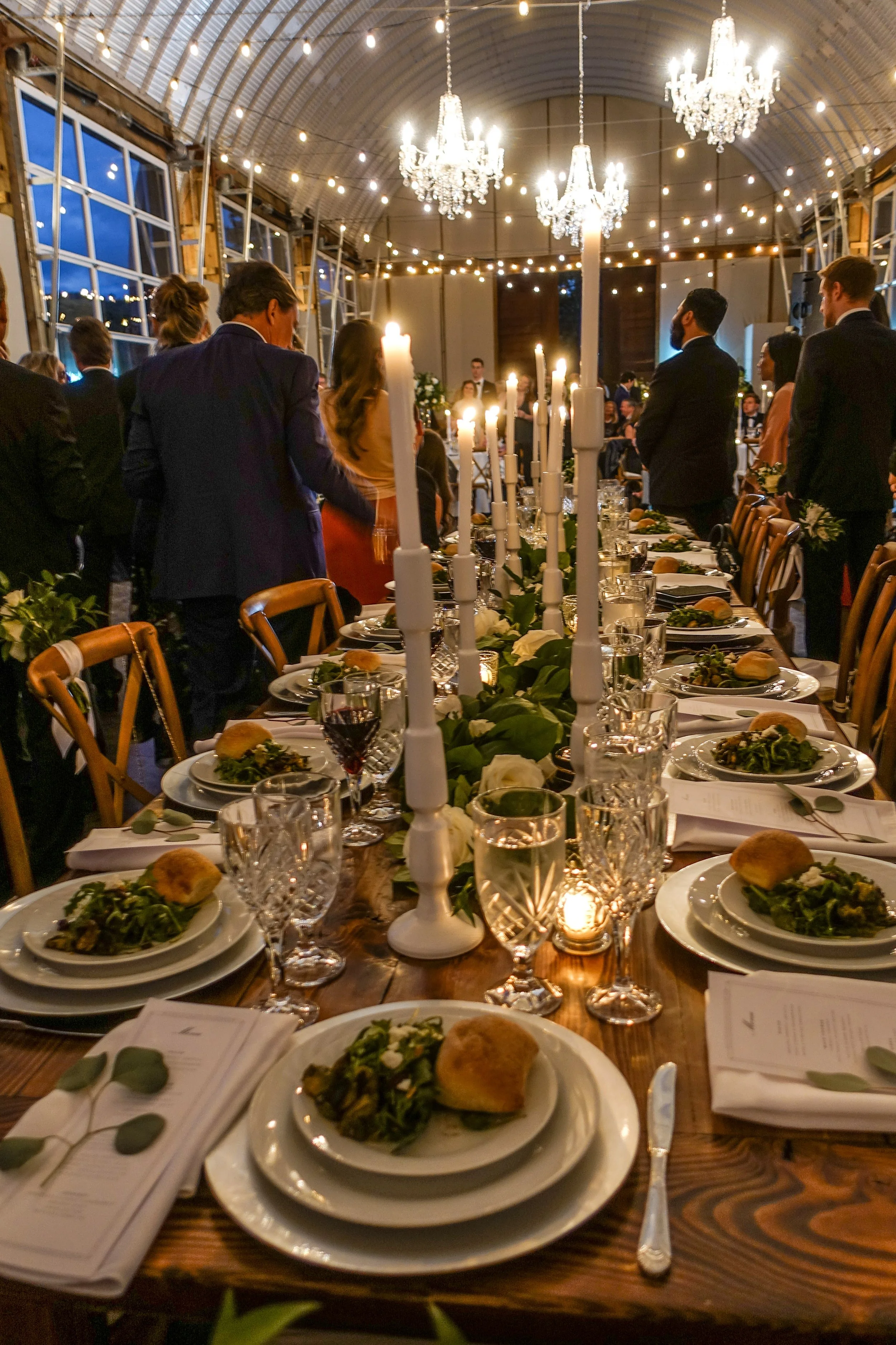 Candlelit wedding reception table with formal place settings