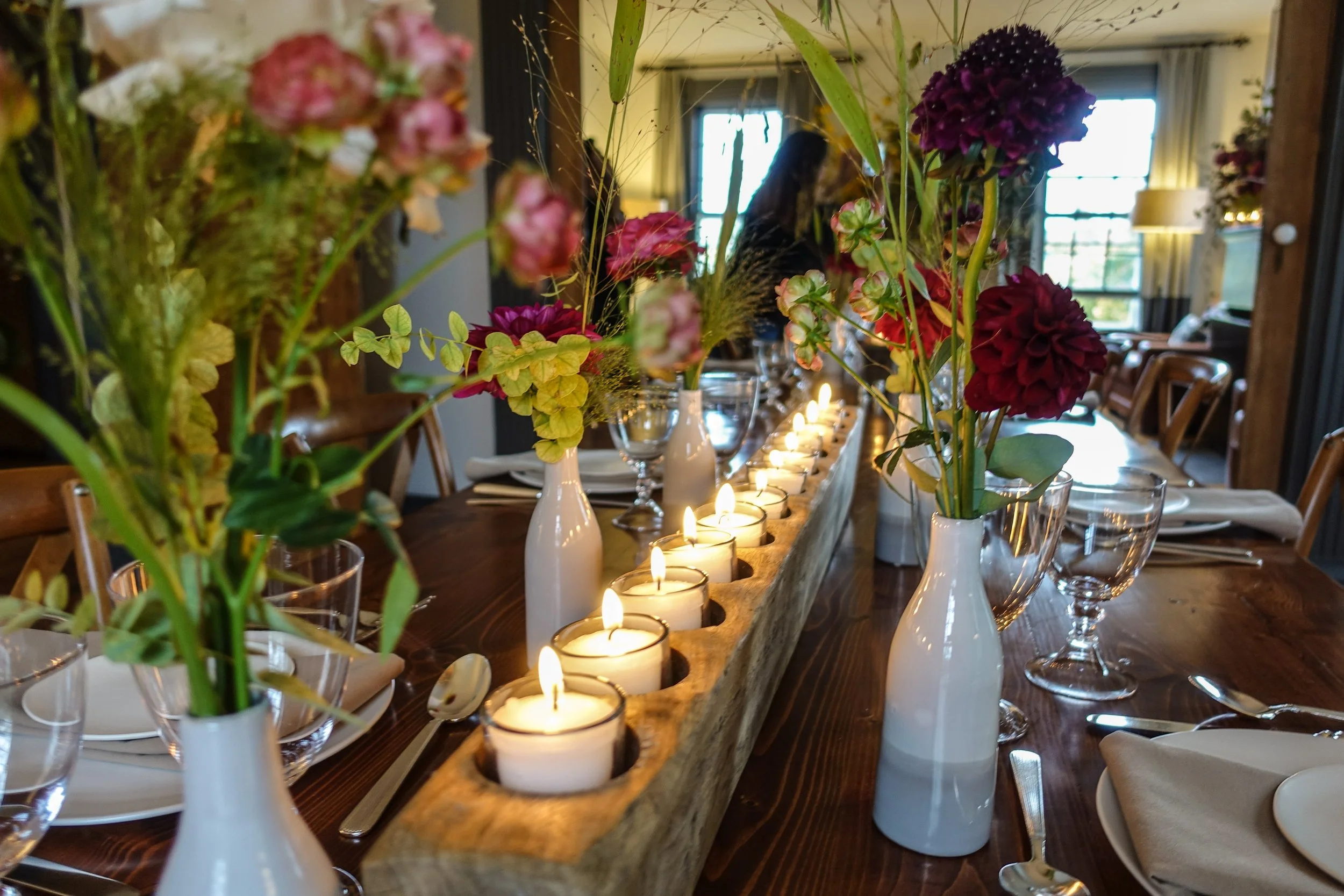 Long wedding table decorated with candles and florals