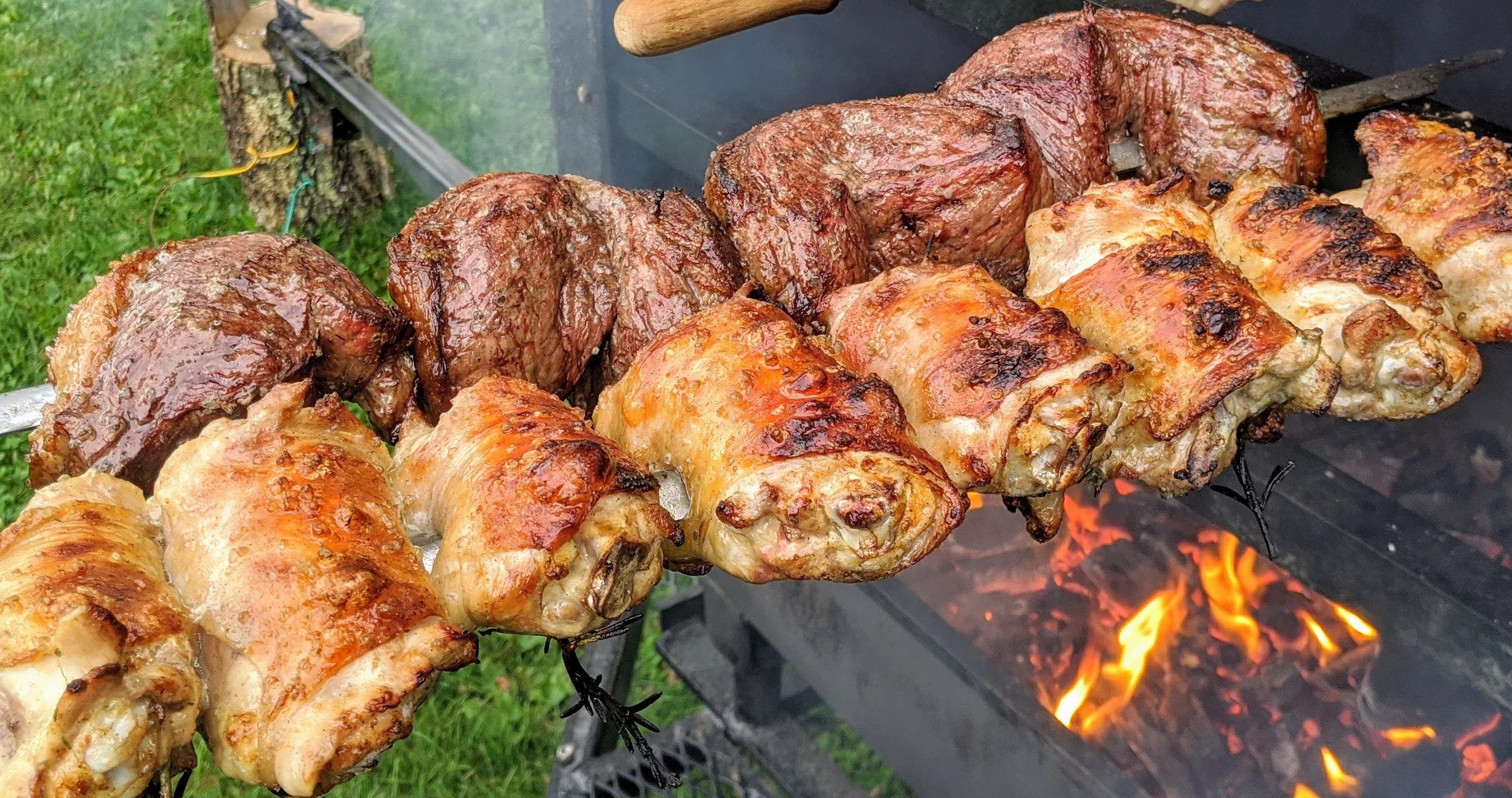 Pichana steak and chicken thighs grilling over open fire