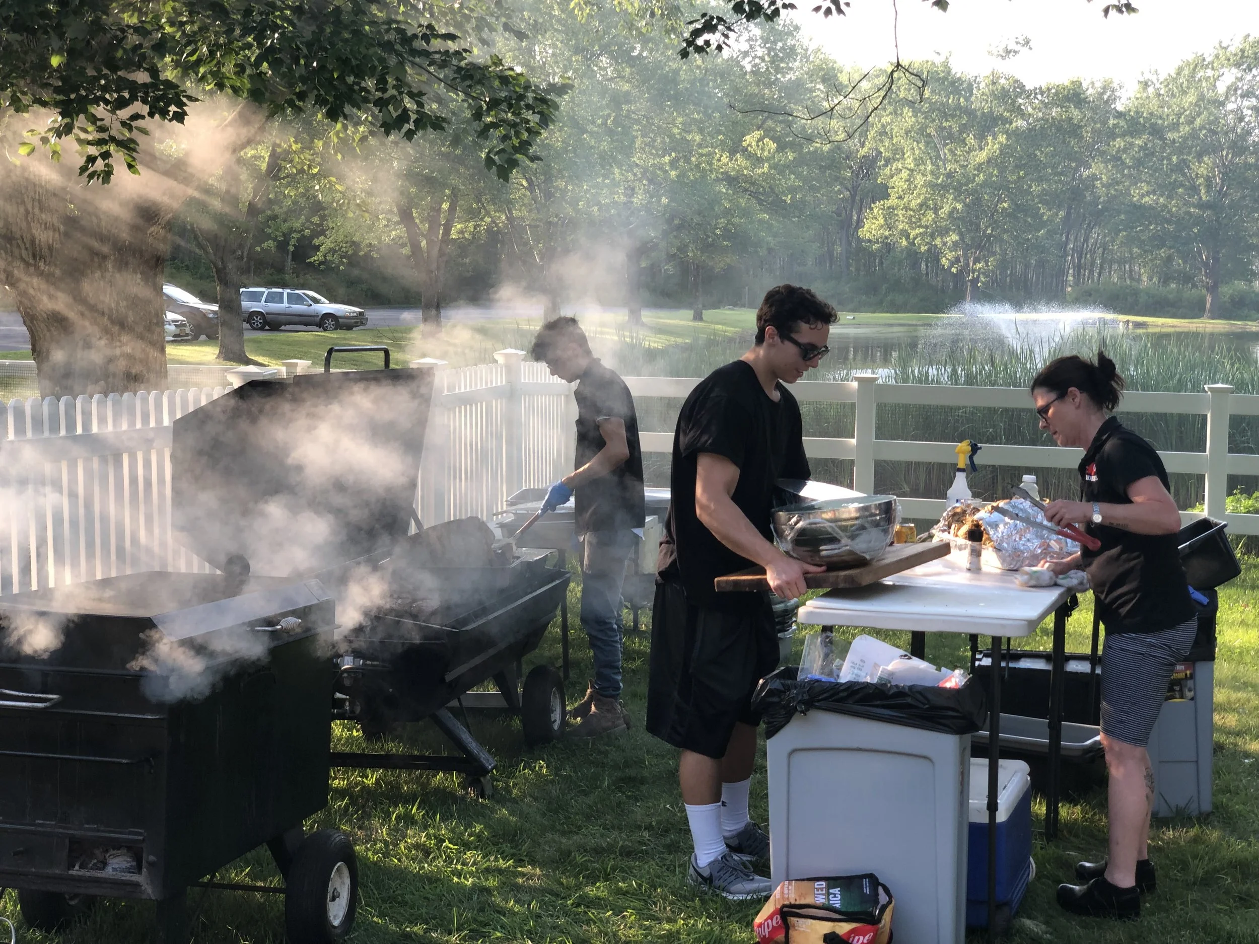 Catering chefs working smokers and grills at outdoor event