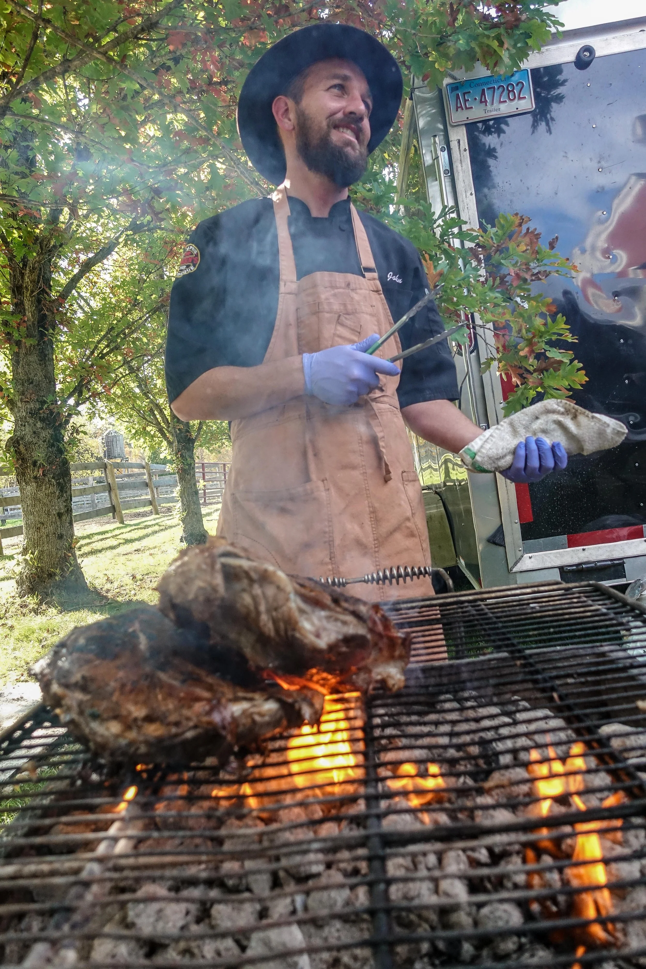 lamb roasting on open-fire grill, BBQ catering