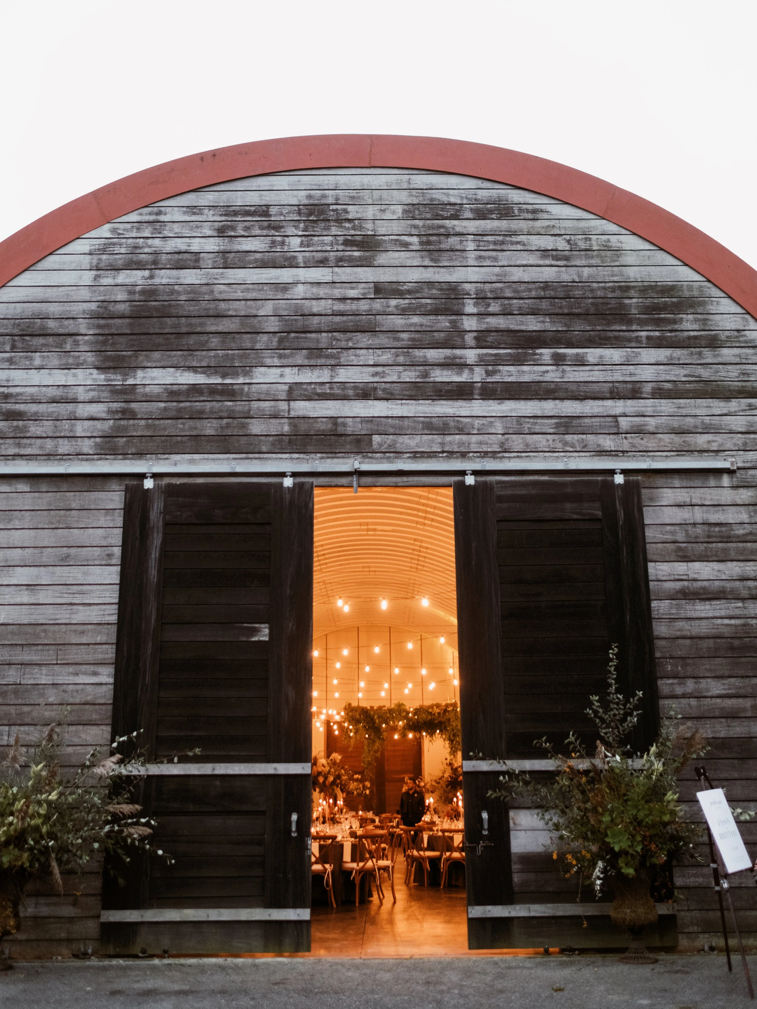 Cozy lit barn wedding venue entrance at dusk