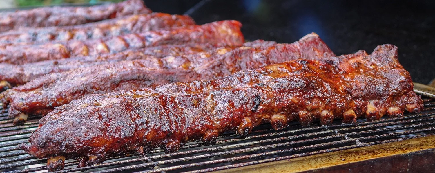a rack of ribs in a grill almost perfectly cooked