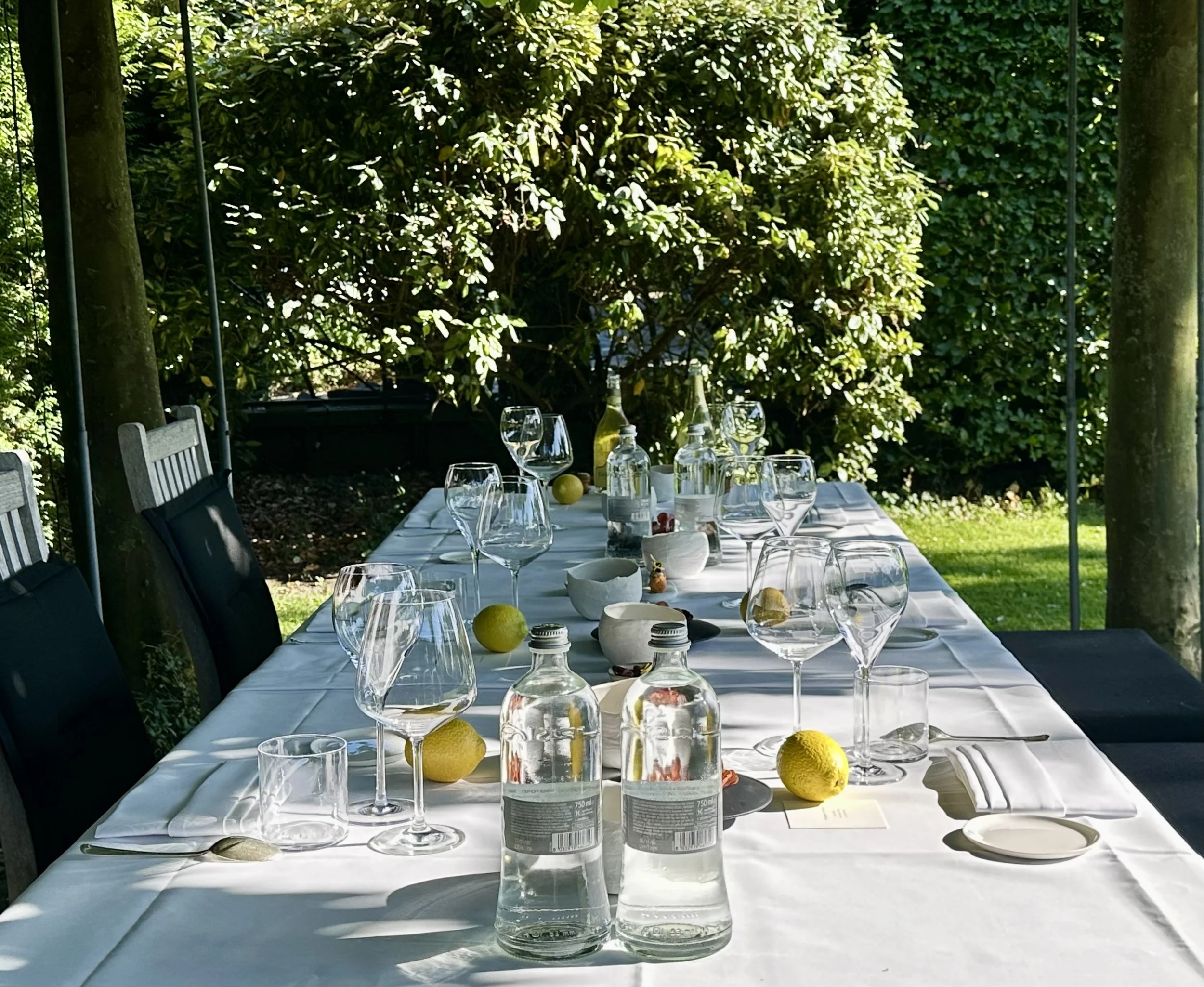 Mediterranean outdoor dining table set among trees and greenery for a private Alma Nómada experience.