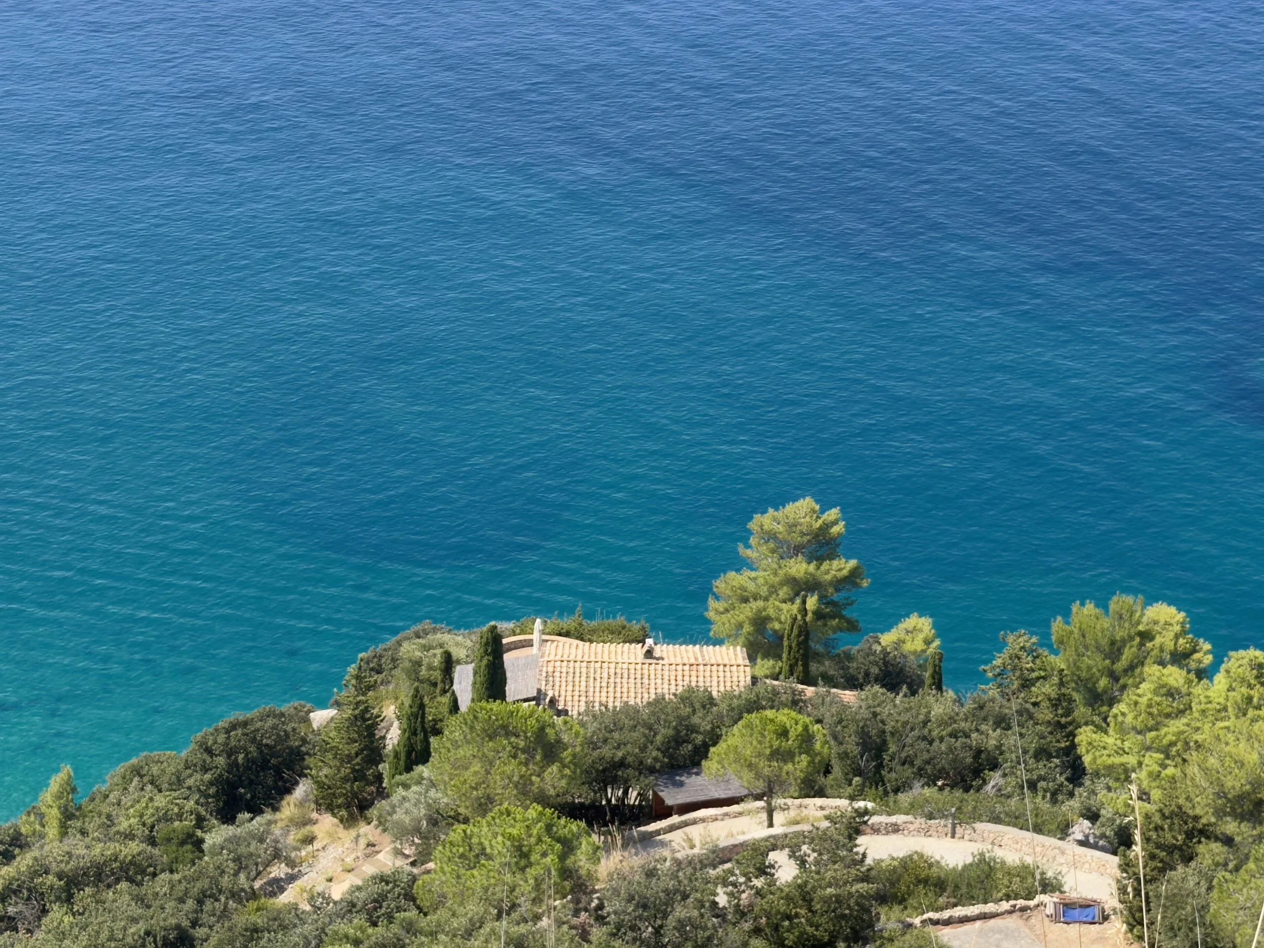 Private Mediterranean villa surrounded by pine trees overlooking the sea.