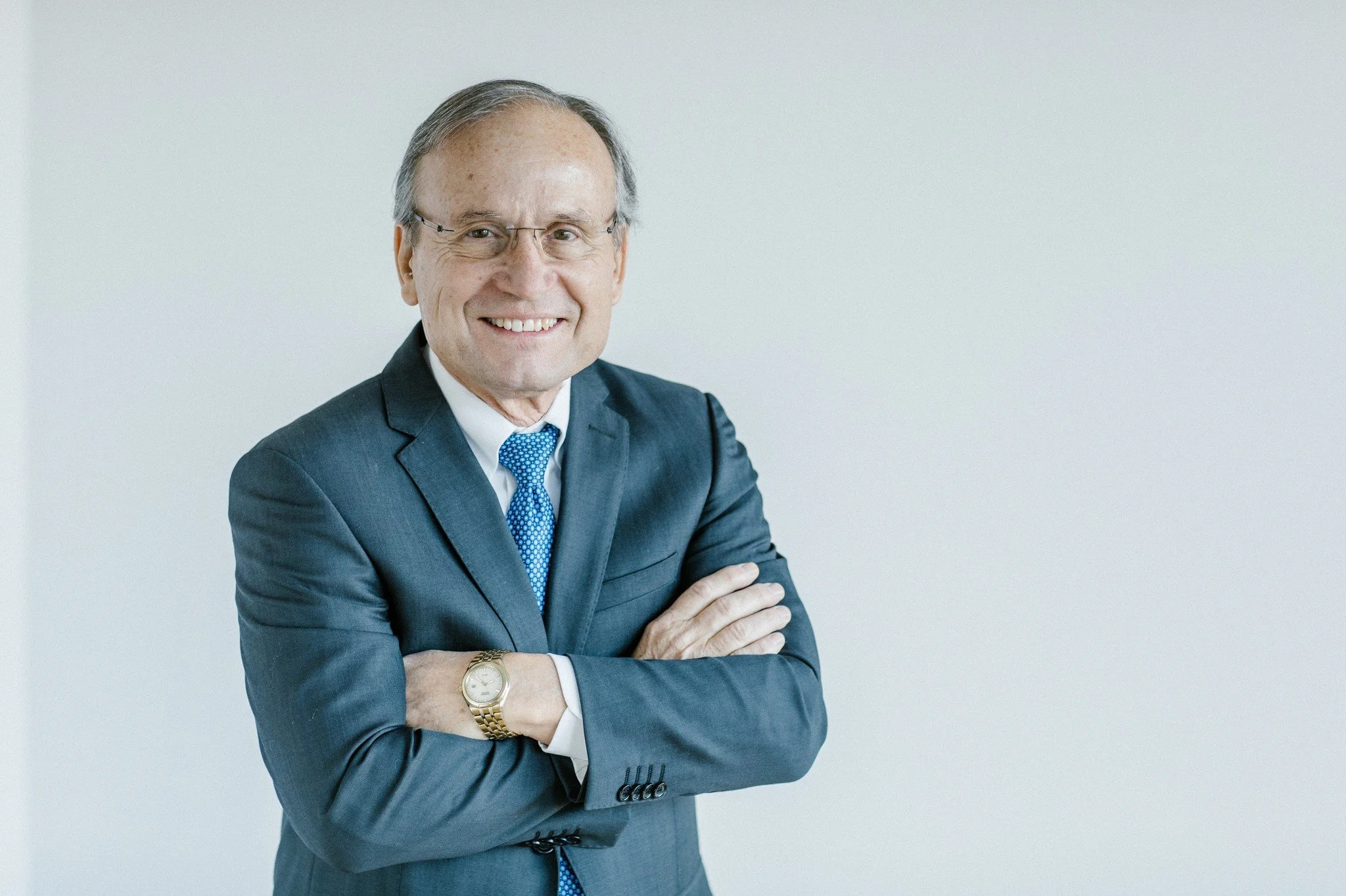 Older man standing in grey suit
