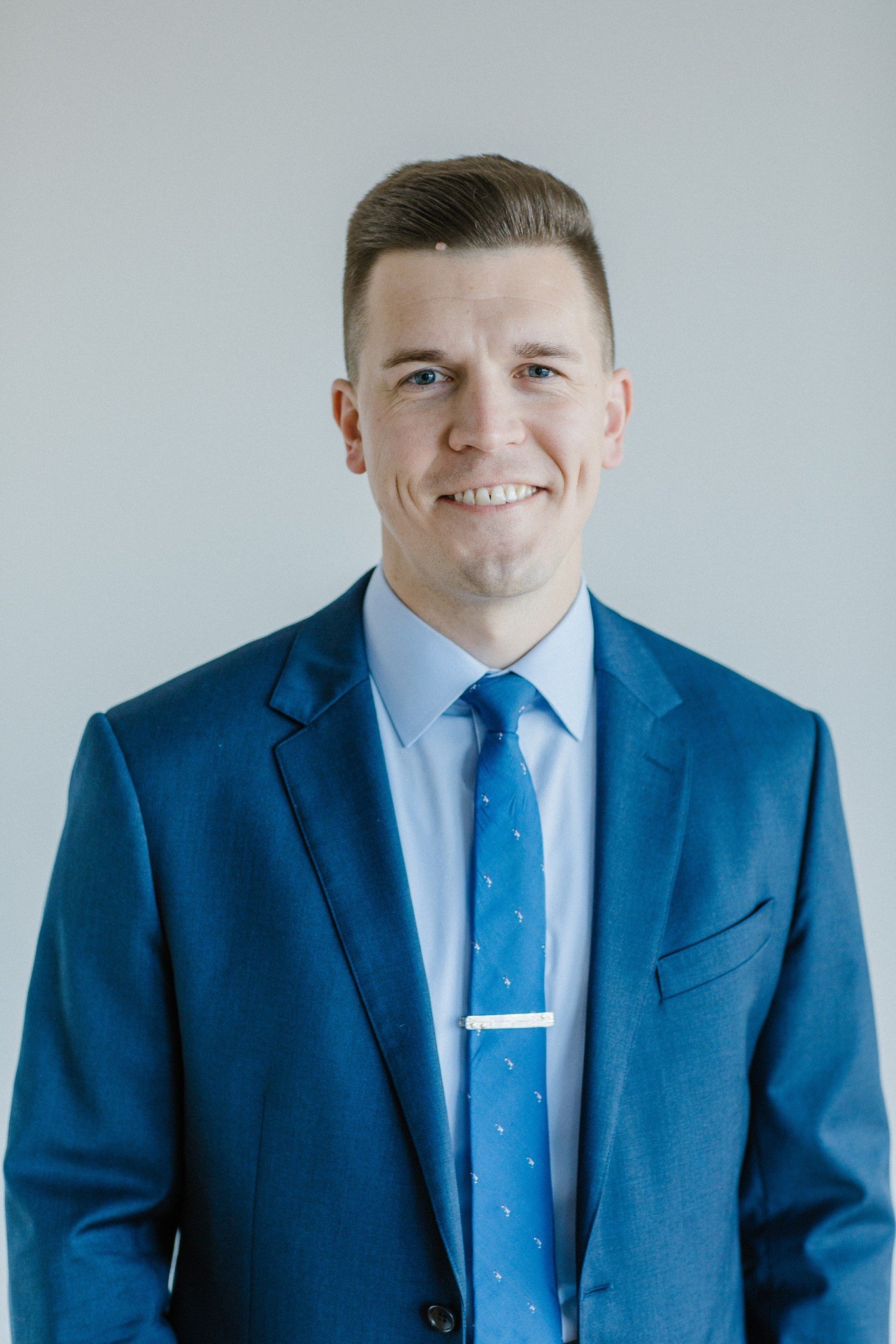 Man in blue suit smiling at camera