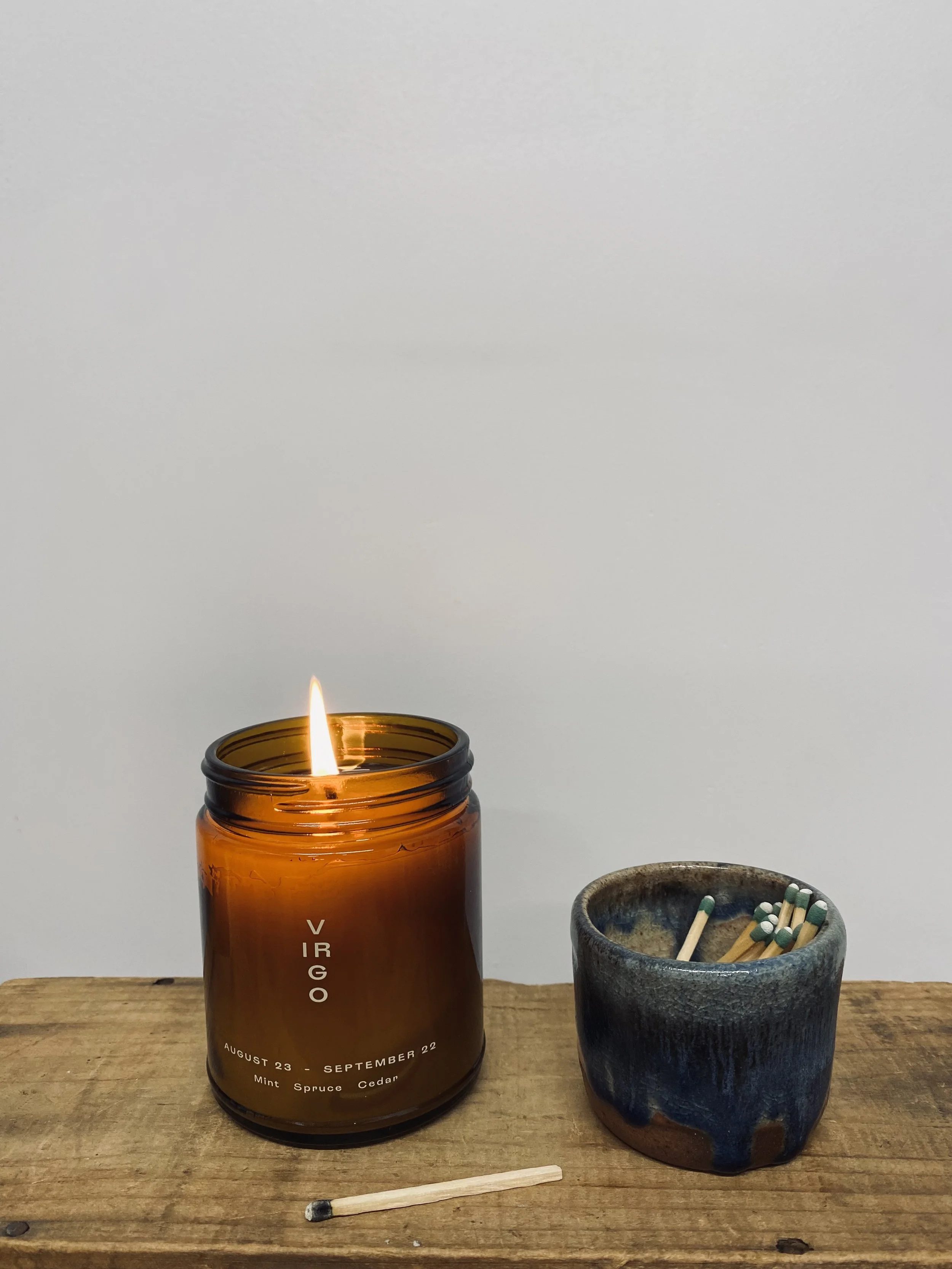 Virgo Zodiac candle lit with matches in ceramic pot
