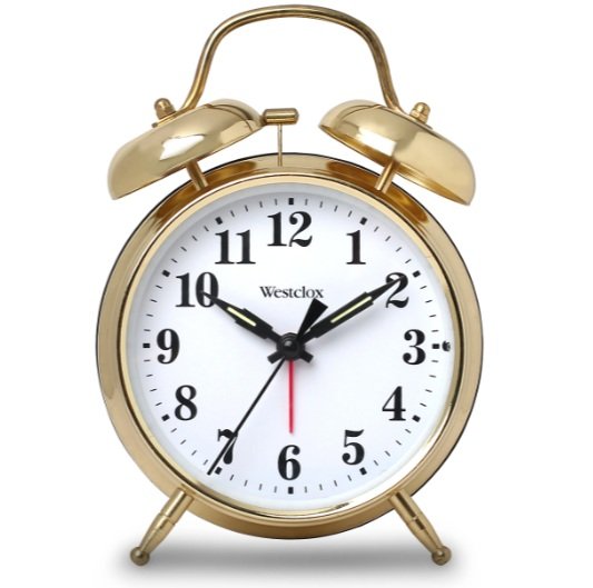 A gold-colored vintage alarm clock showing the time as 10:11 and 36 seconds.