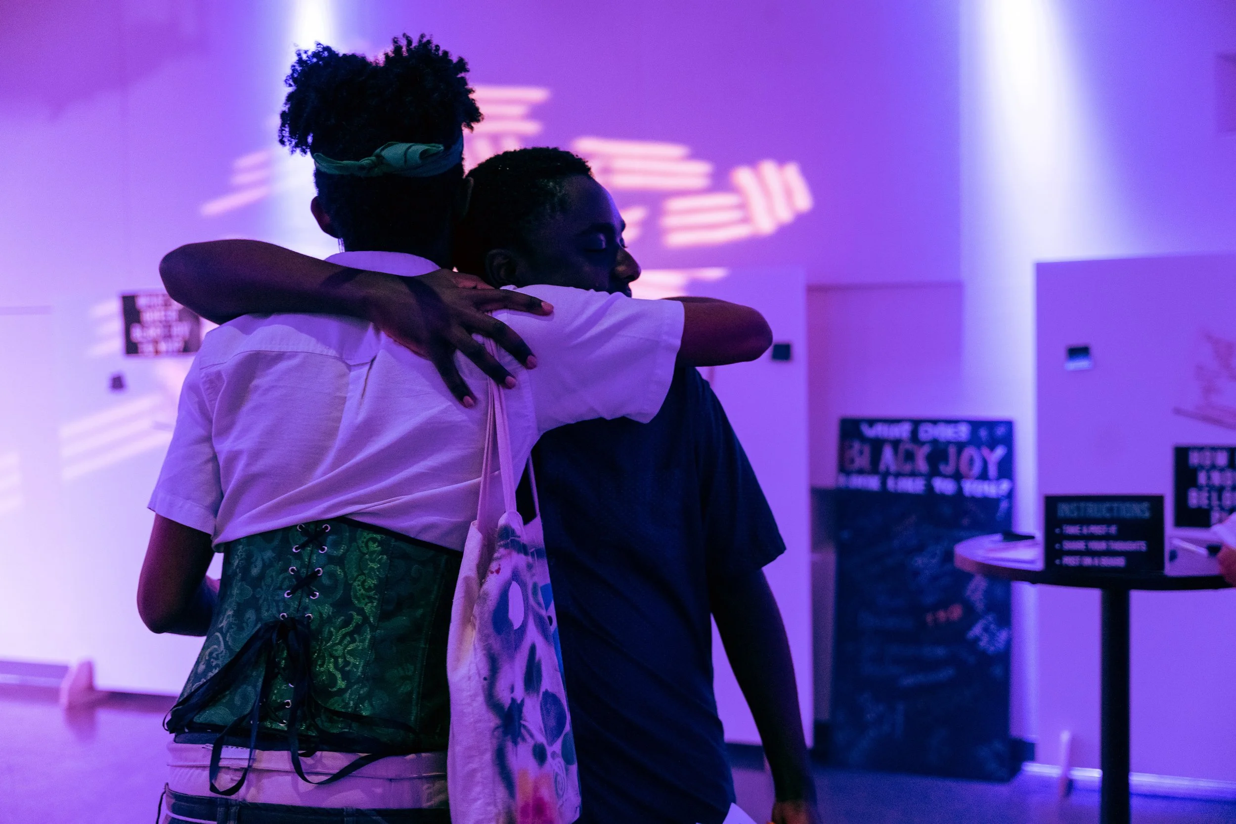 image of two Black people embracing in a softly lit room