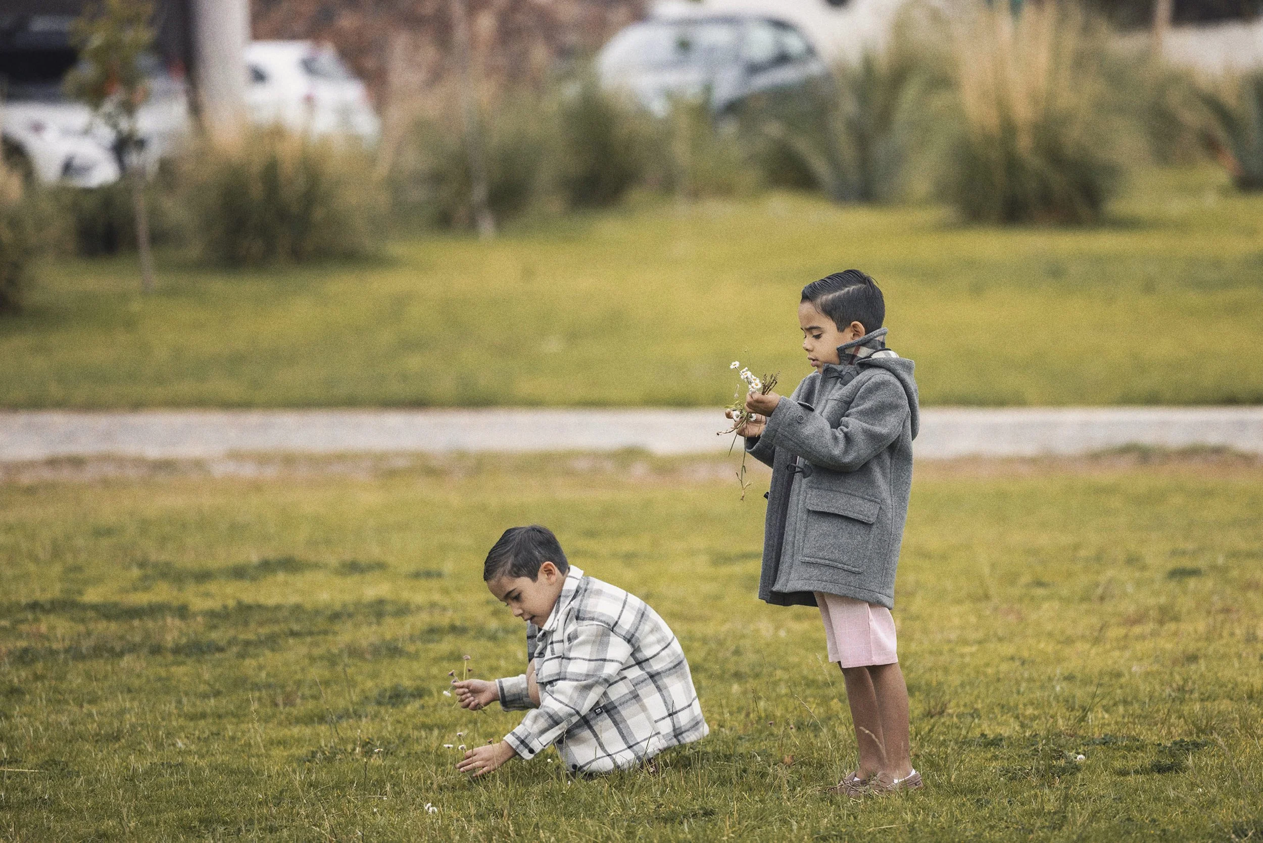 Fotografía documental de niños jugando en jardín durante boda, escena espontánea y natural.