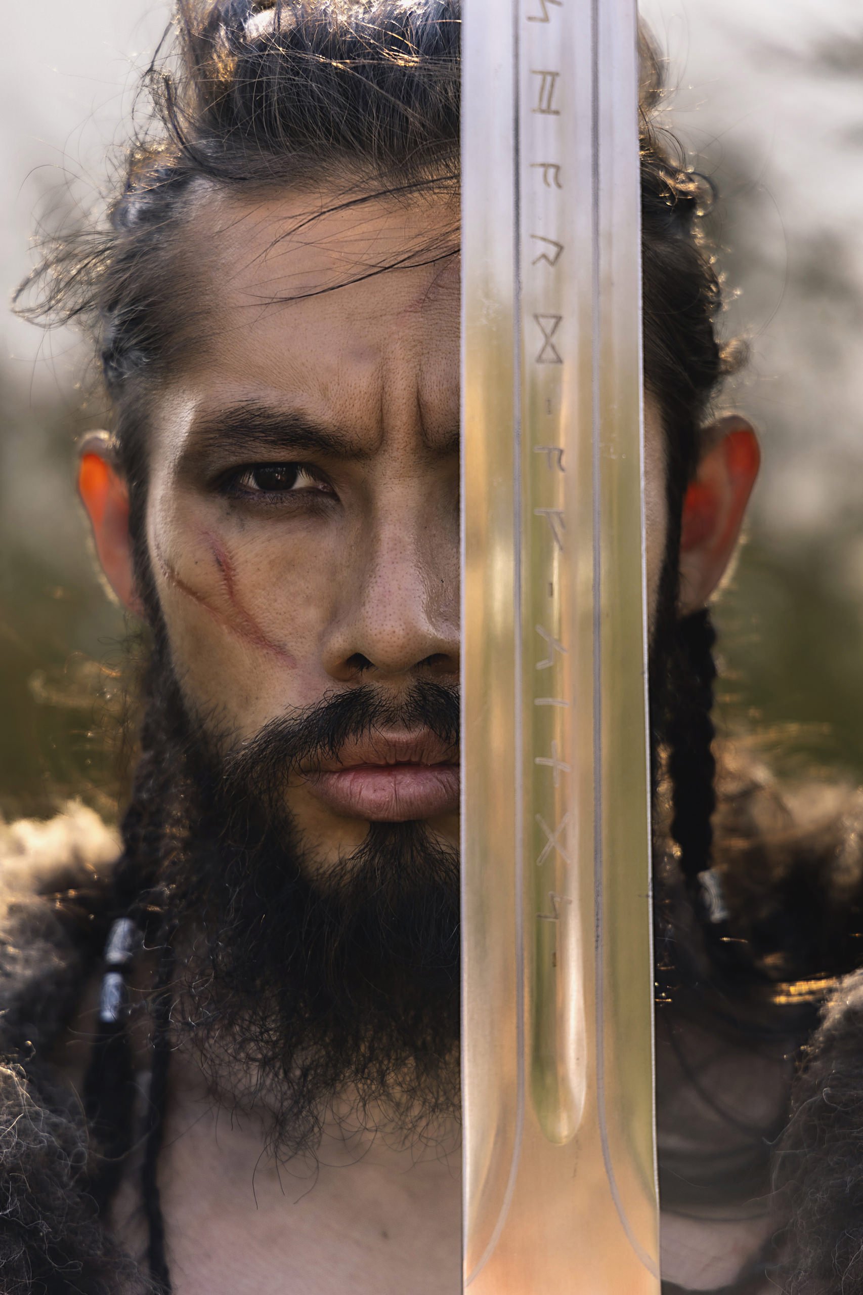 Primer plano de hombre con barba, rostro parcialmente cubierto por objeto transparente, mirada intensa en exterior.