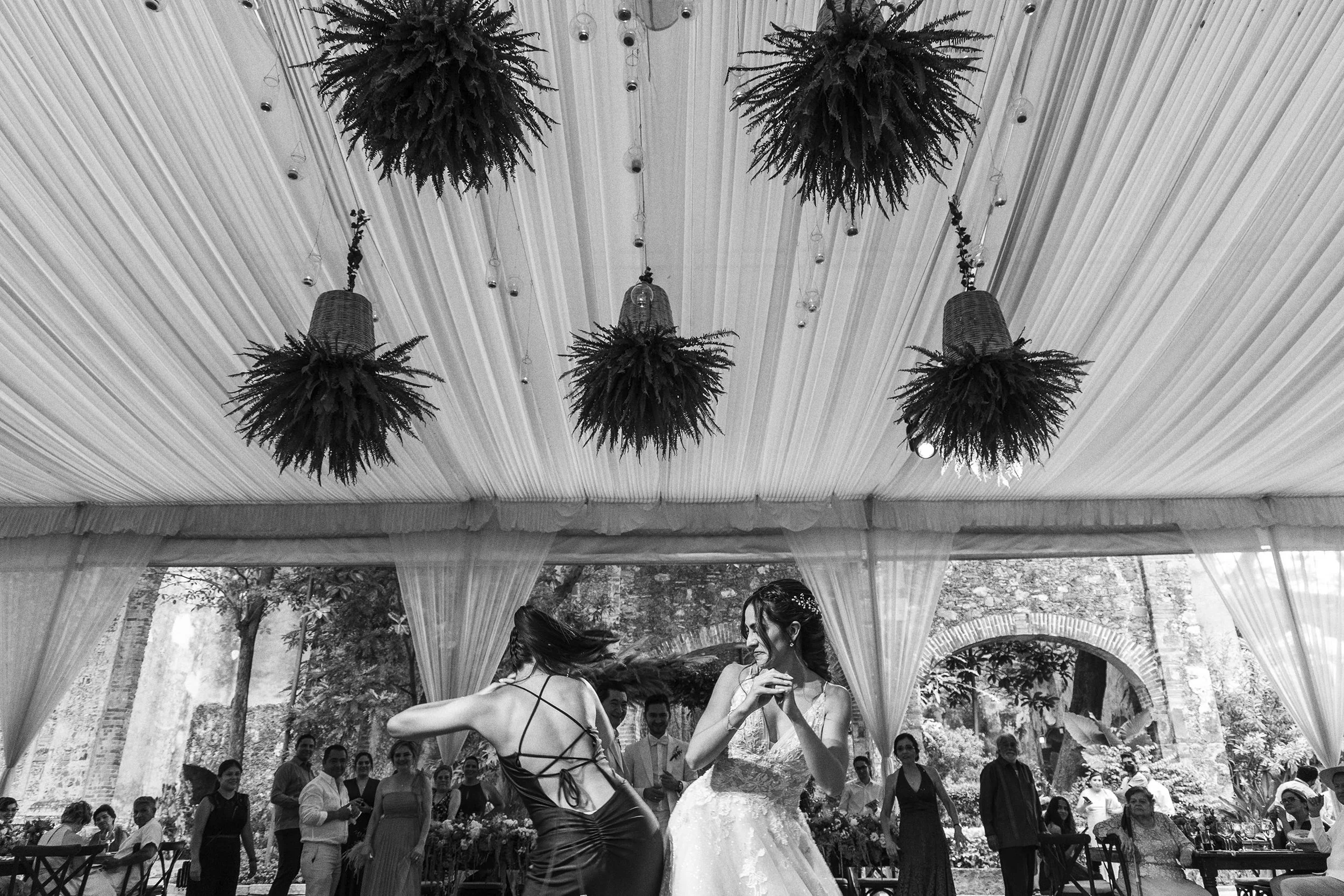 Fotografía documental en blanco y negro de pareja bailando durante la celebración.