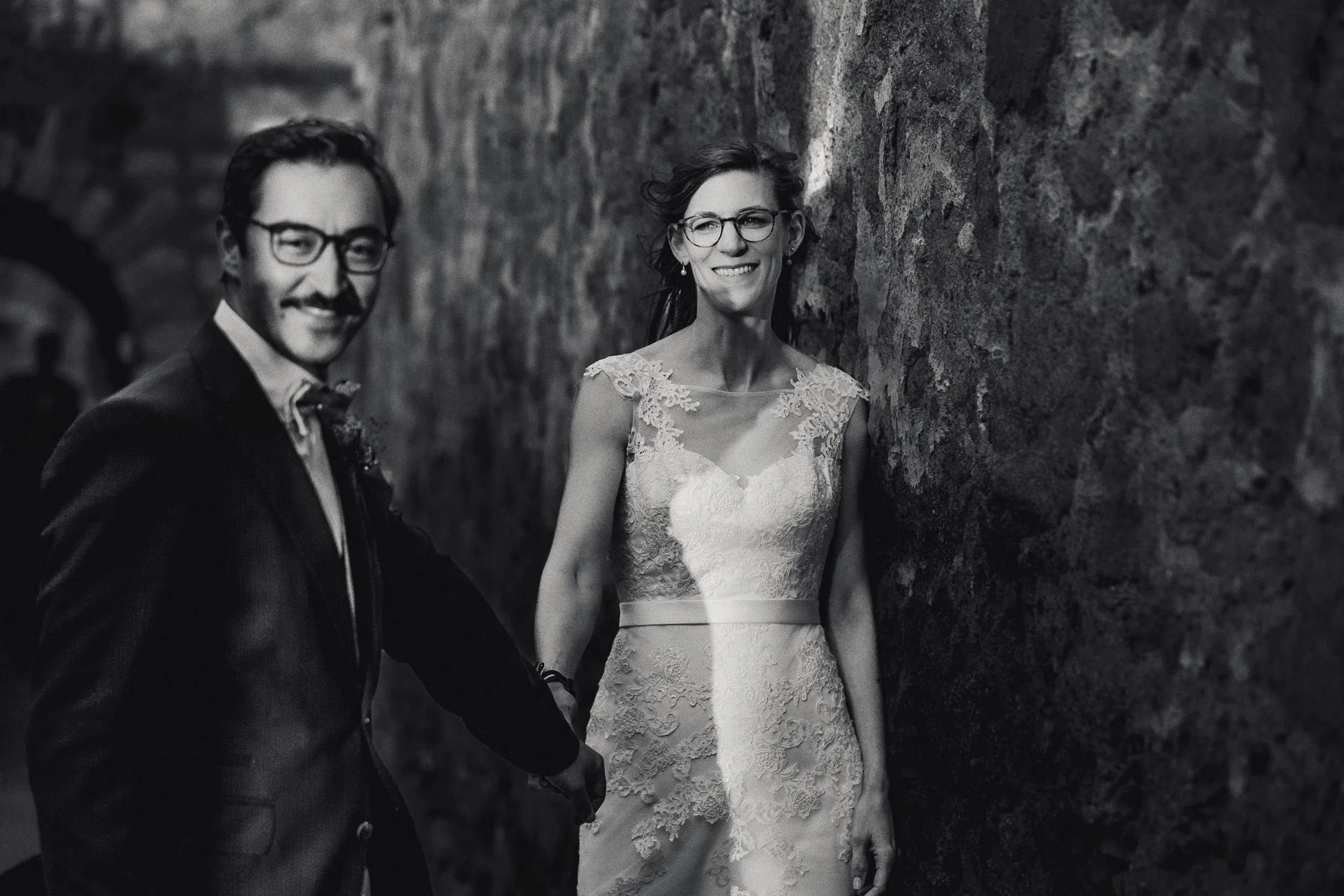 Fotografía en blanco y negro de novios caminando juntos, mirada hacia el frente y gesto sereno.