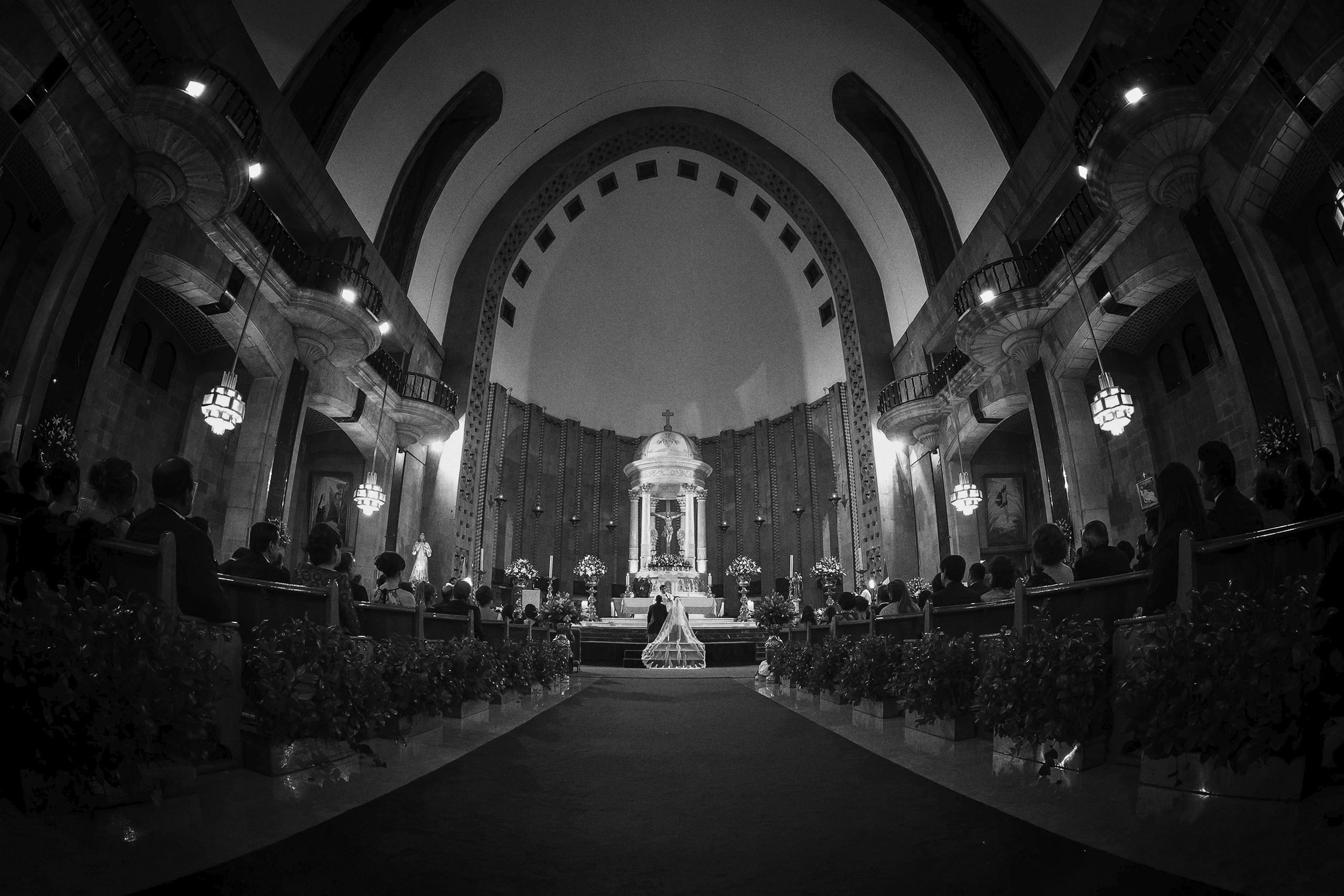 Fotografía en blanco y negro de interior de iglesia, vista amplia del altar y arquitectura.