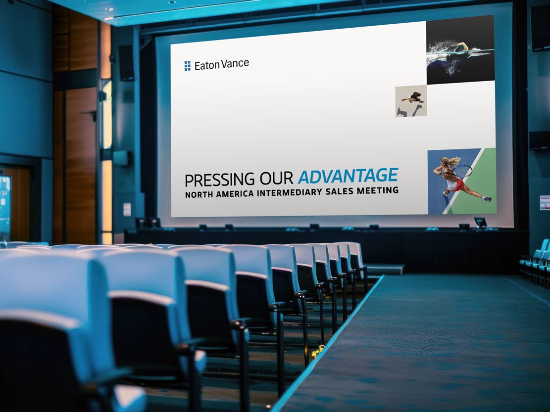 Conference room with a large projection screen displaying a presentation titled 'Pressing Our Advantage' for an Eaton Vance North America Intermediary Sales Meeting. The screen features images of a swimmer, a diver, and a tennis player.