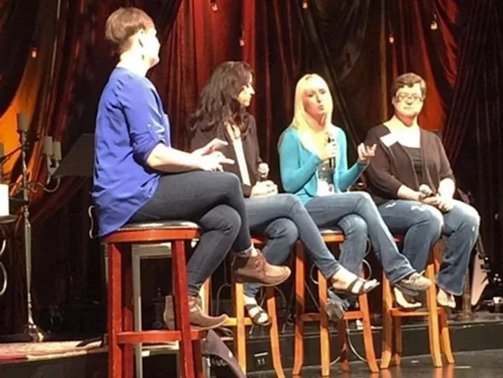 Local St. Charles, IL Therapist; Four women sitting on stools, holding microphones, engaged in a panel discussion on stage with a curtain backdrop.