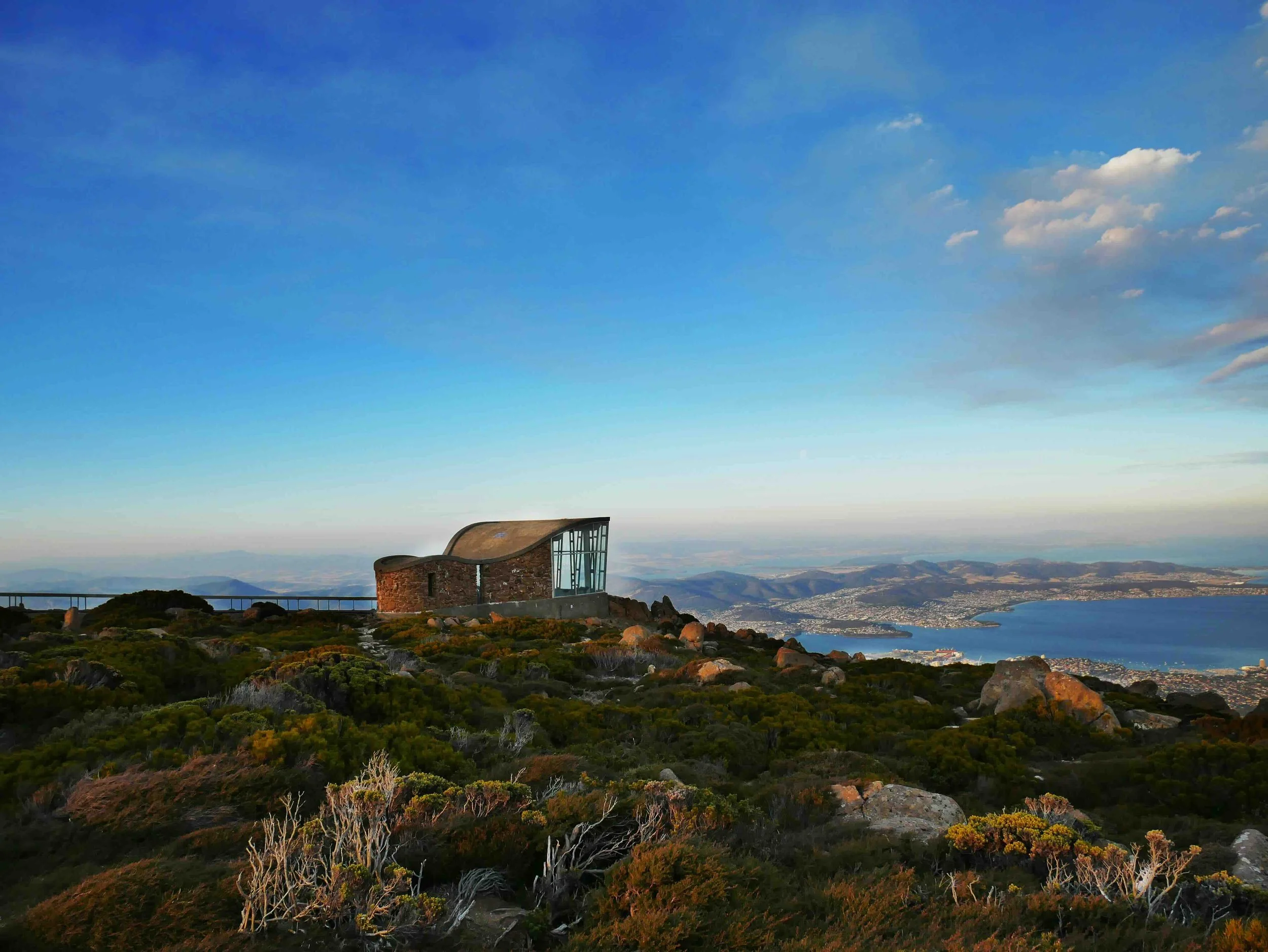 The stone and glass summit shelter atop kunanyi / Mount Wellington, 1,271 metres above Hobart, Tasmania, with sweeping panoramic views across the Derwent River estuary and city