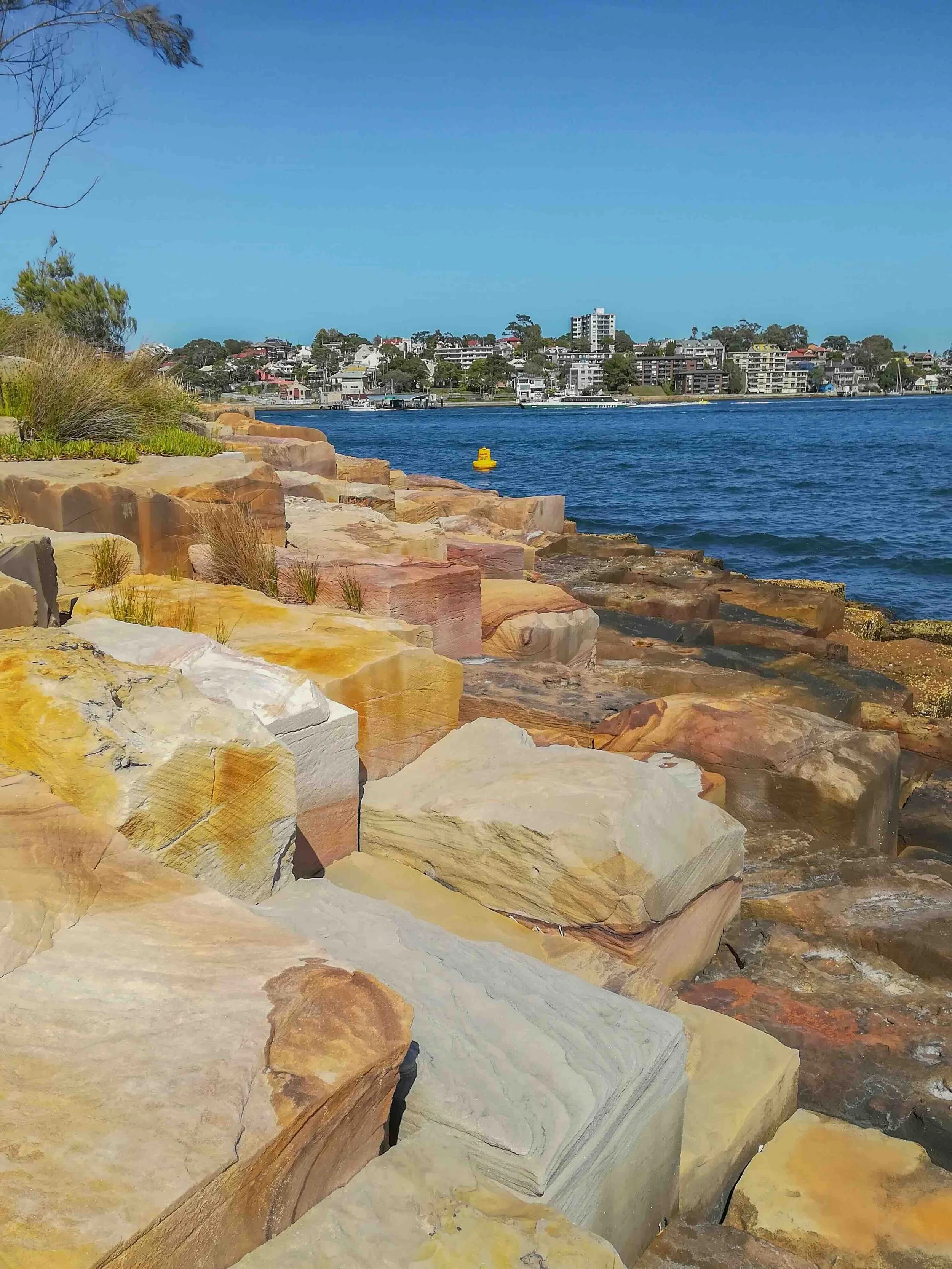 Golden sandstone rock formations along the Sydney Harbour foreshore — a geology and Indigenous heritage landscape explored on Libertas Travel's Sydney curriculum-linked high school excursions.