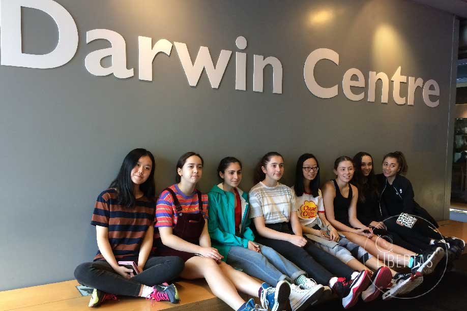 Student group tour waiting at the Darwin Centre on the bench underneath the sign