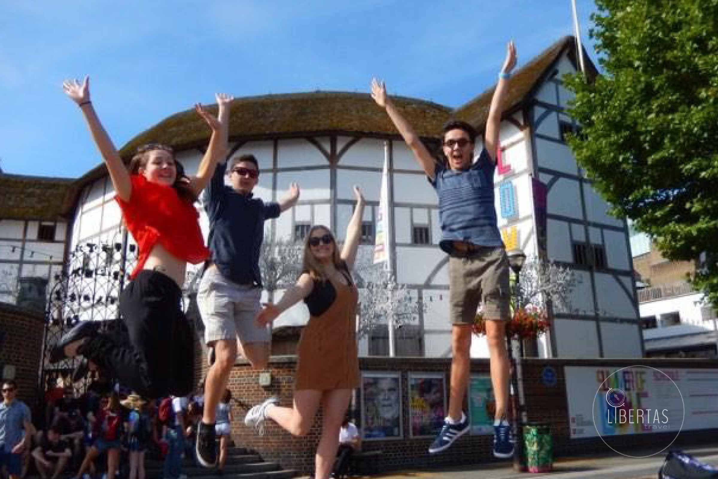 High school group tour children jumping for you about to watch a live theatre performance at the Globe Theatre