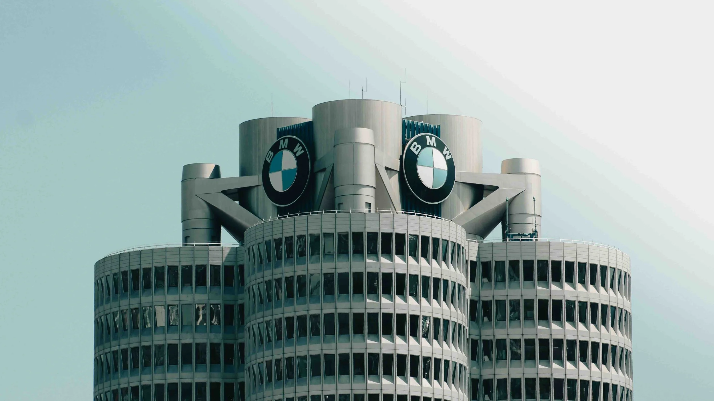 Munich, Germany | Close-up of the BMW Headquarters "Four-Cylinder" tower, showing the iconic circular BMW roundel logos mounted at the top.