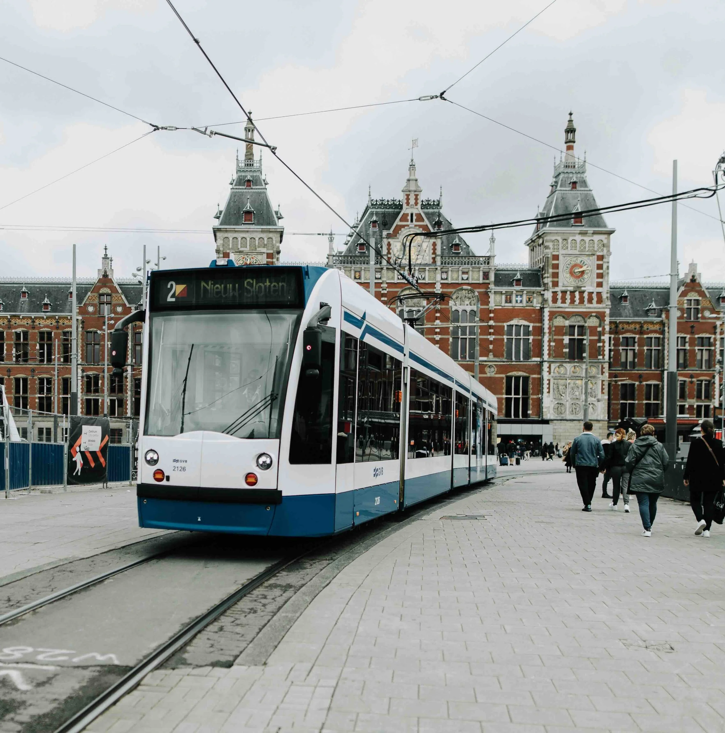 Days 6–7, Amsterdam | GVB tram in front of Amsterdam Centraal Station — arrival/city transit shot for the Amsterdam leg (Amsterdam Exchange Experience and De Nederlandsche Bank day).