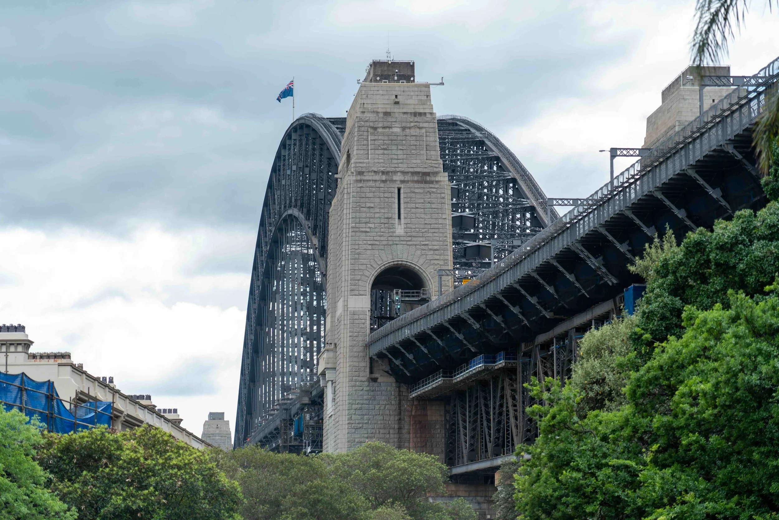 Close-up of the granite pylon and steel arch of the Sydney Harbour Bridge — an engineering and history landmark on Libertas Travel's Sydney curriculum-linked high school excursions.