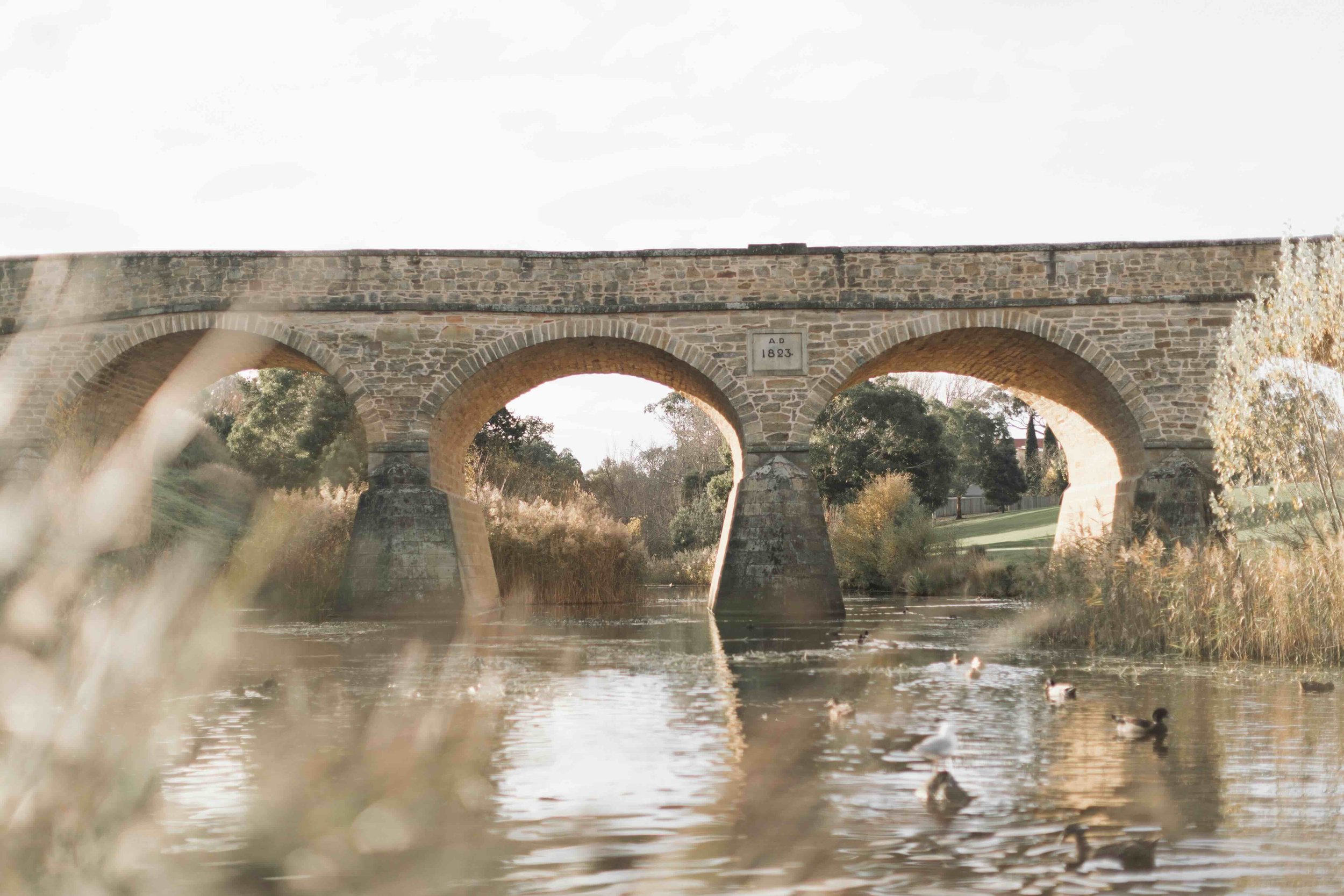 Richmond Bridge, built in 1823 by convict labour, reflected in the Coal River at Richmond, Tasmania — Australia's oldest standing bridge and a Living History landmark