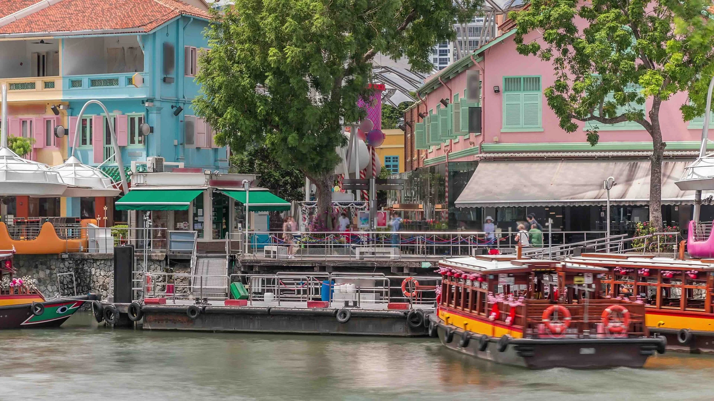 A traditional bumboat glides past restored shophouses on the Singapore River, tracing the trade routes that shaped a global city.