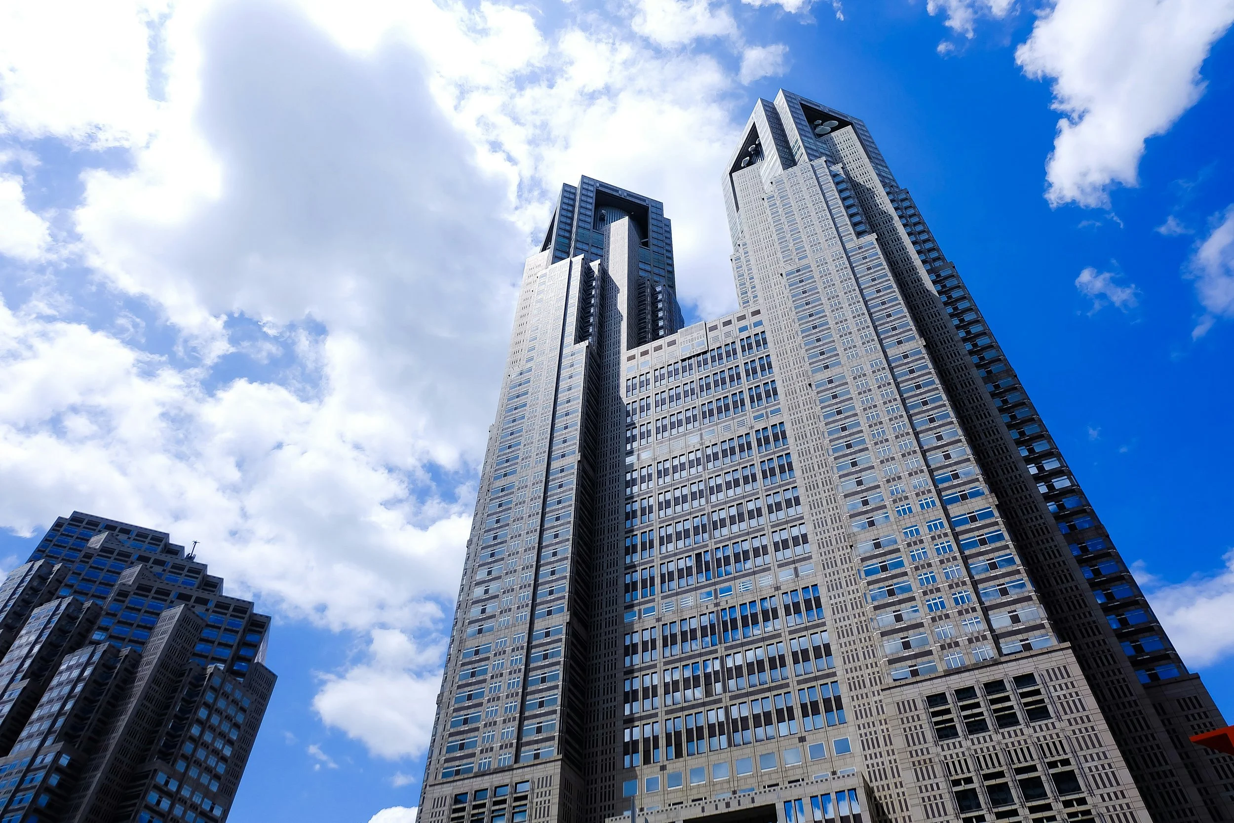 Tall, modern tower with sleek glass and steel architecture against a clear sky, showcasing Tokyo’s administrative center and cityscape views.