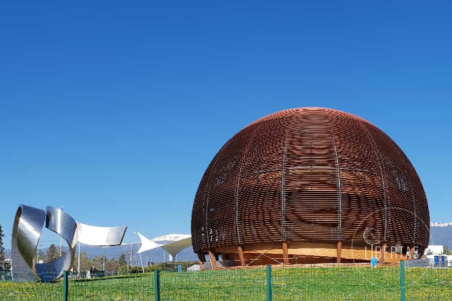 The icon CERN dome open for workshops and educational tours , pictured here with the woven copper coloured exterior set against a blue sky and the sculptural garden that surrounds